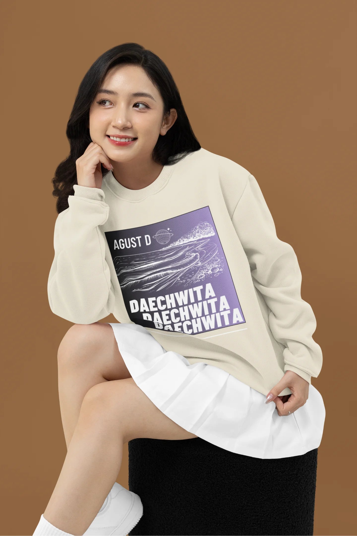 First front view of a female model wearing a cream sweatshirt featuring a bold design inspired by BTS member Suga's alter ego, August D. Ideal for BTS fans (ARMY) and K-Pop enthusiasts who love rap music and artist individuality.