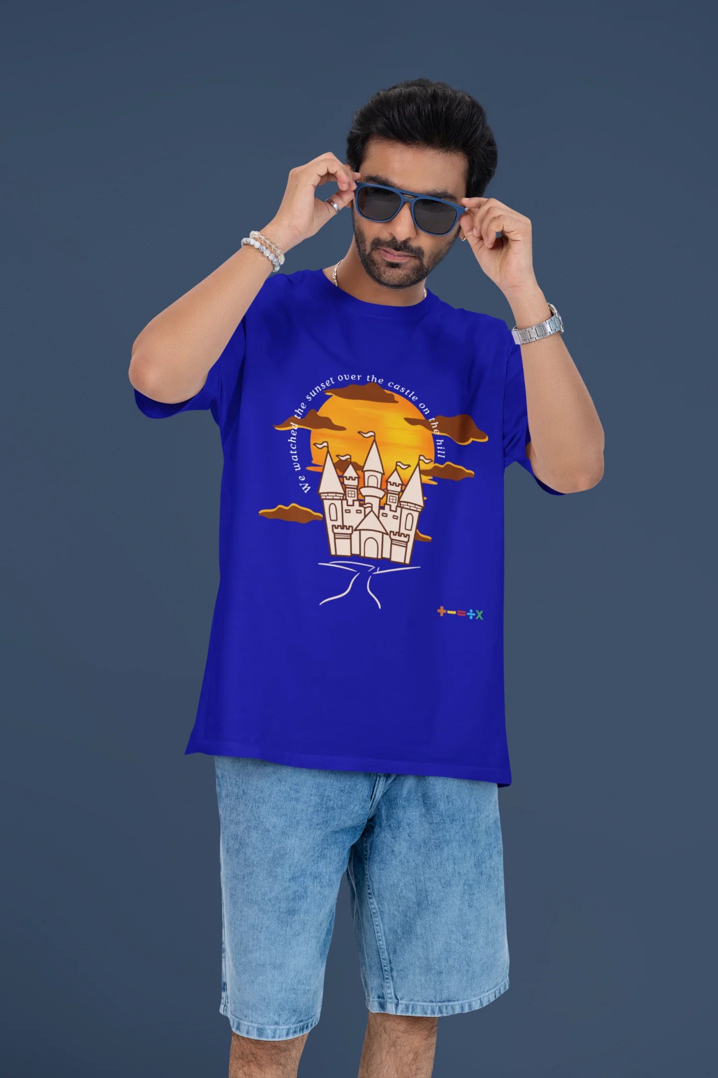 4th front view of a male model wearing a royal blue oversized t-shirt featuring a nostalgic sunset and castle design, related to Ed Sheeran's "Castle on the Hill."