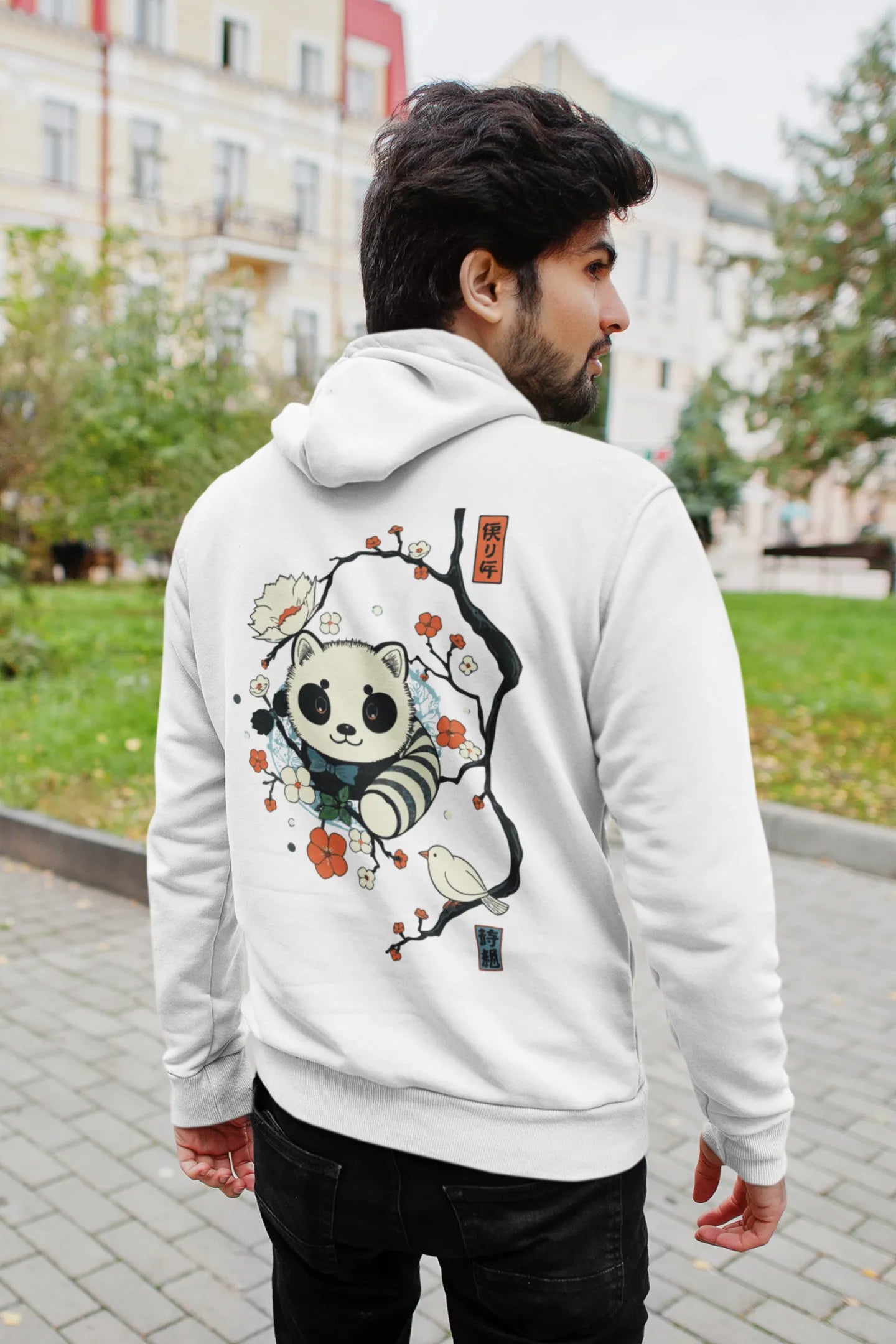 Back view of a male model wearing a white hoodie with a panda fox surrounded by bamboo.