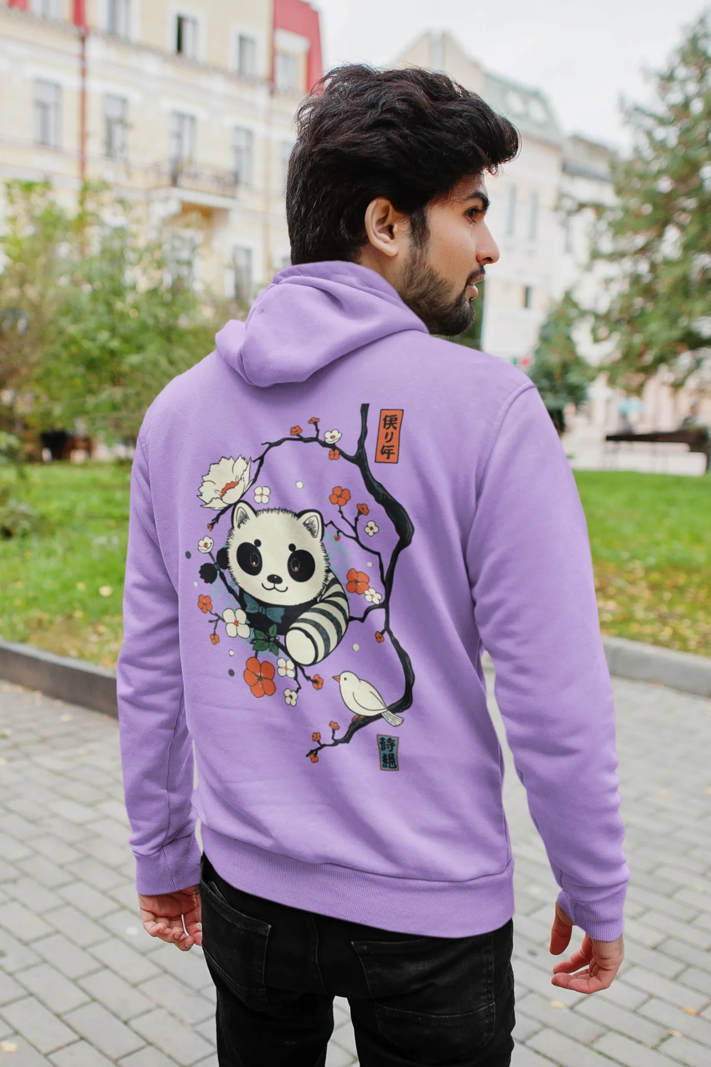Back view of a male model wearing a lavender hoodie with a panda fox surrounded by bamboo.