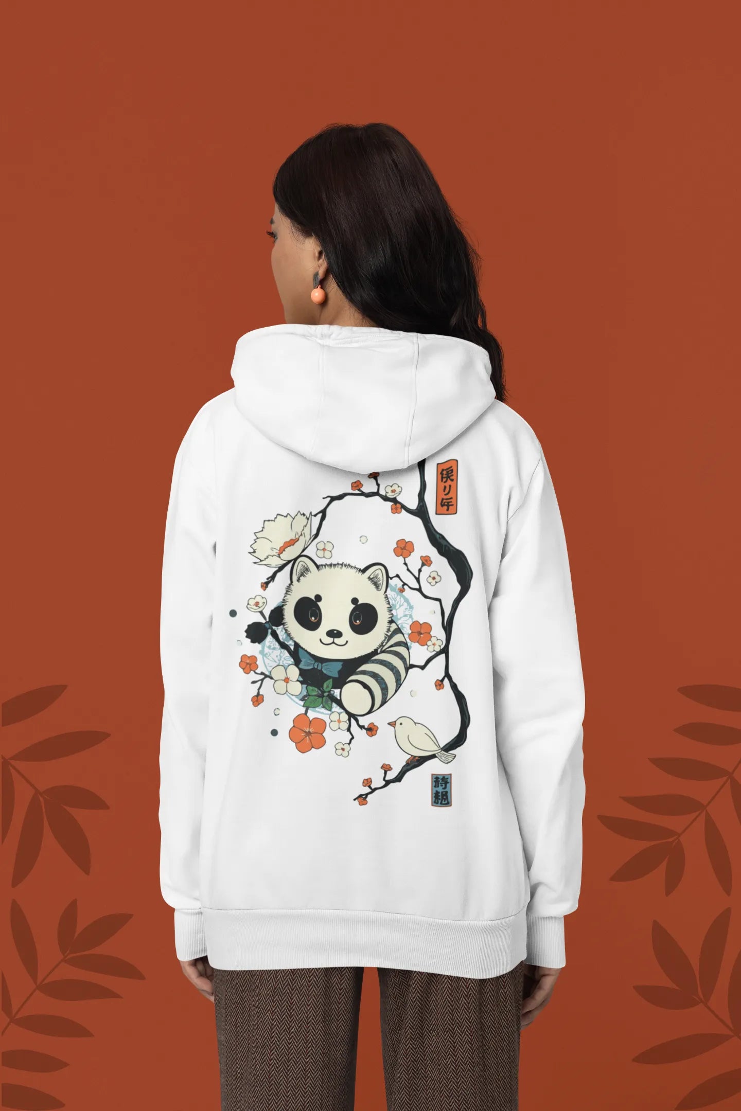 Back view of a female model wearing a white hoodie with a panda fox surrounded by bamboo.