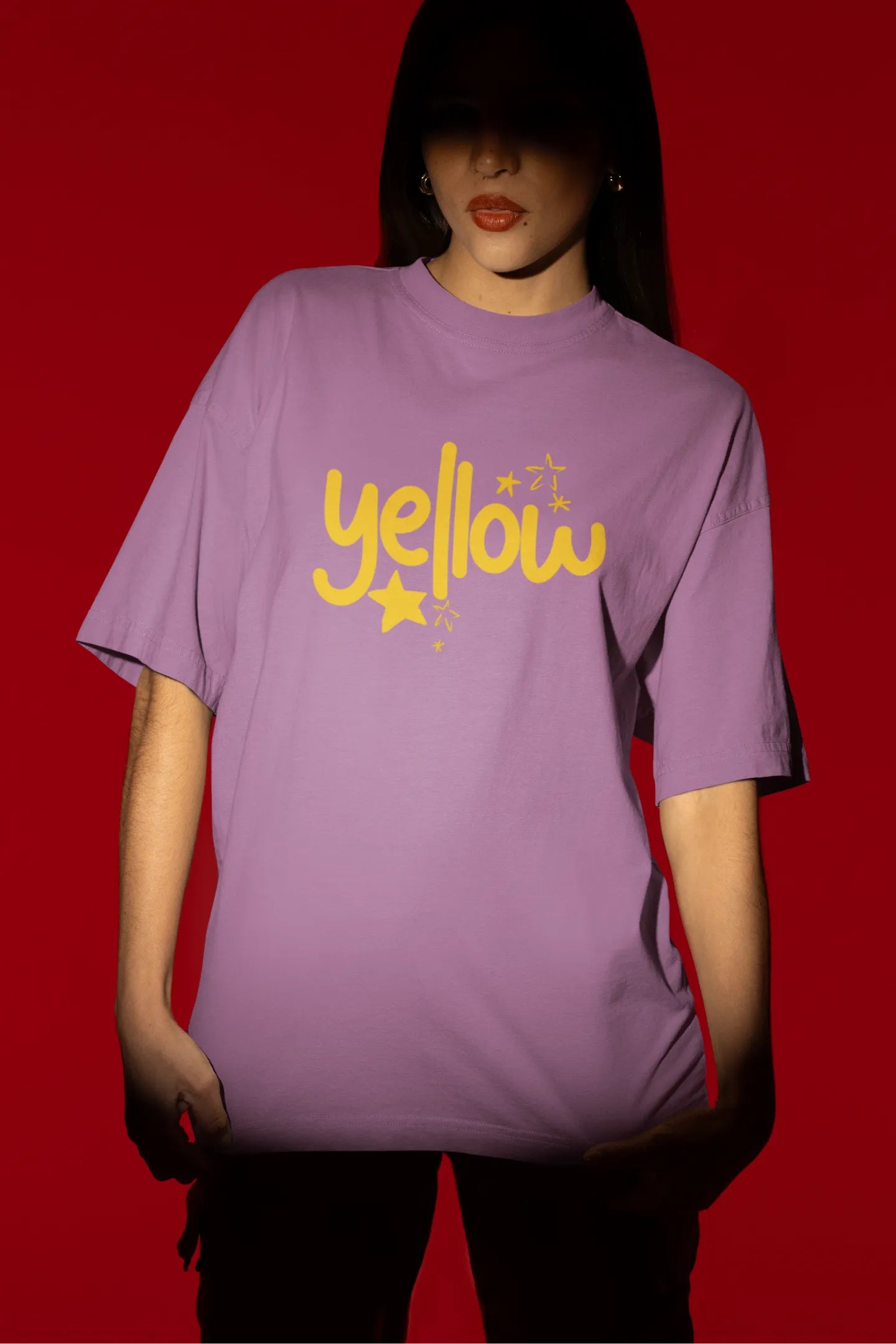 Fourth front view of a female model wearing a dirty purple oversized t-shirt with the "Yellow" album artwork by Coldplay.