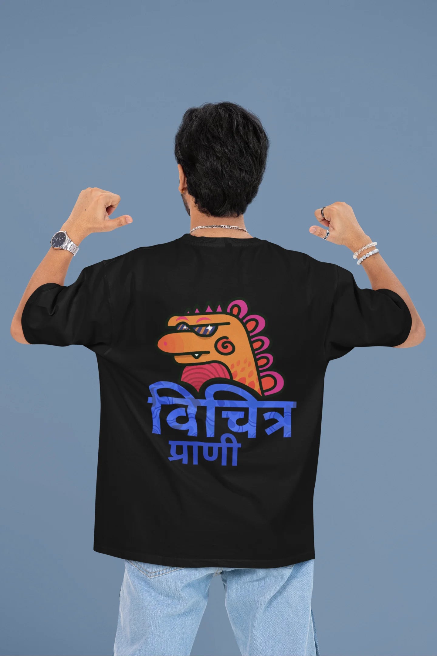 Back view of a male model wearing a black oversized tee with the phrase "Vichitra Pranee" (meaning "Strange being" or "alien") in a stylish Hindi font.