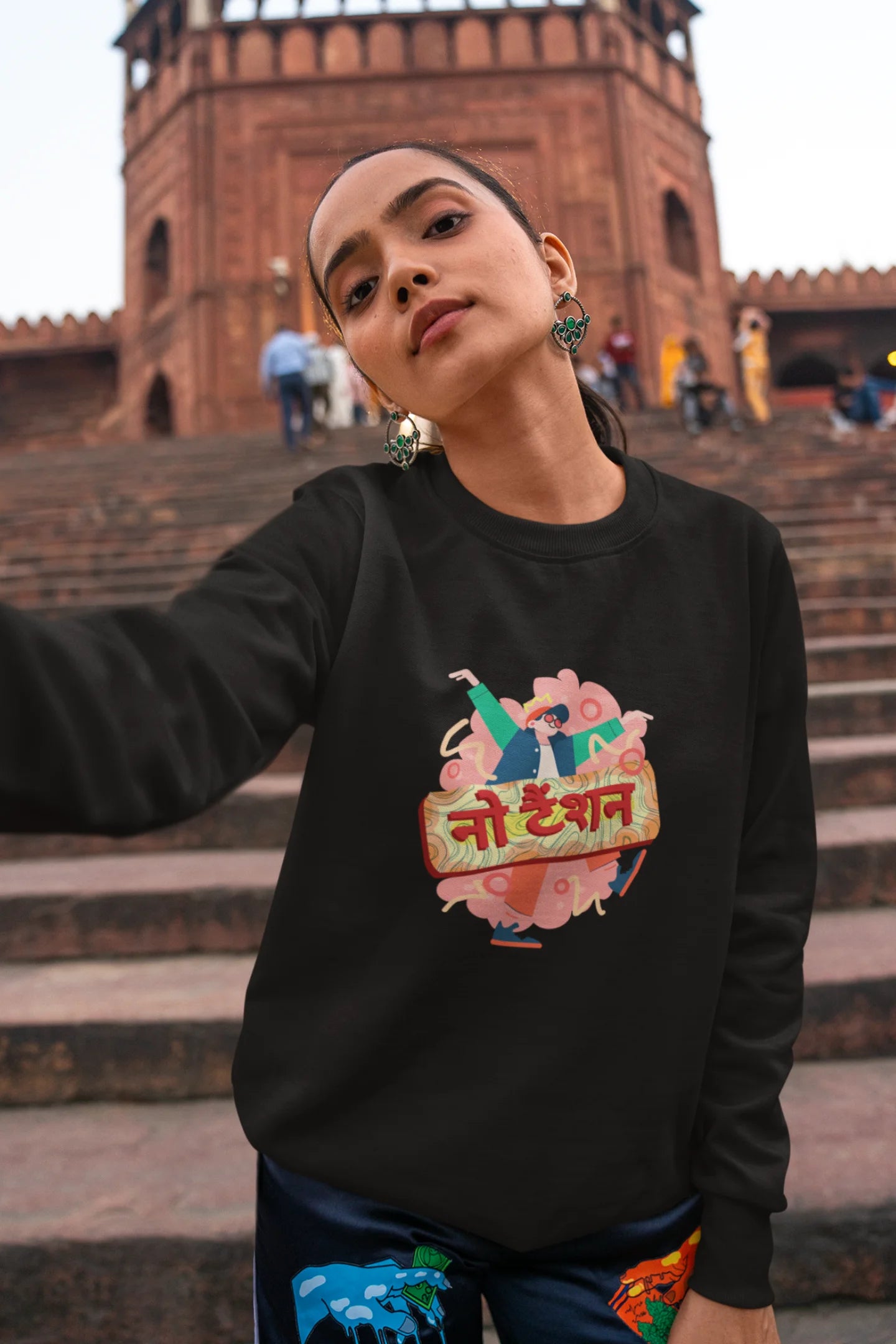 4th front view of a female model wearing a black oversized t-shirt with the phrase "No Tension" in a relaxed, unique script.