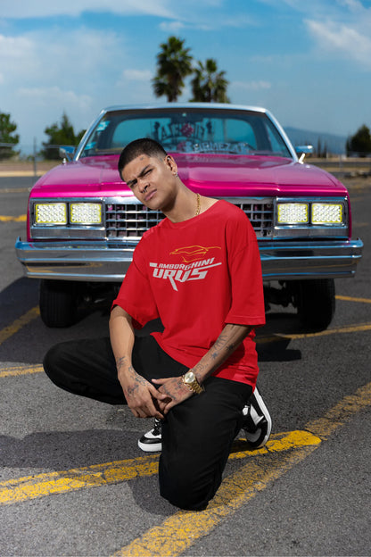Front view of a male model wearing a red oversized t-shirt featuring a design of a Lamborghini Urus.