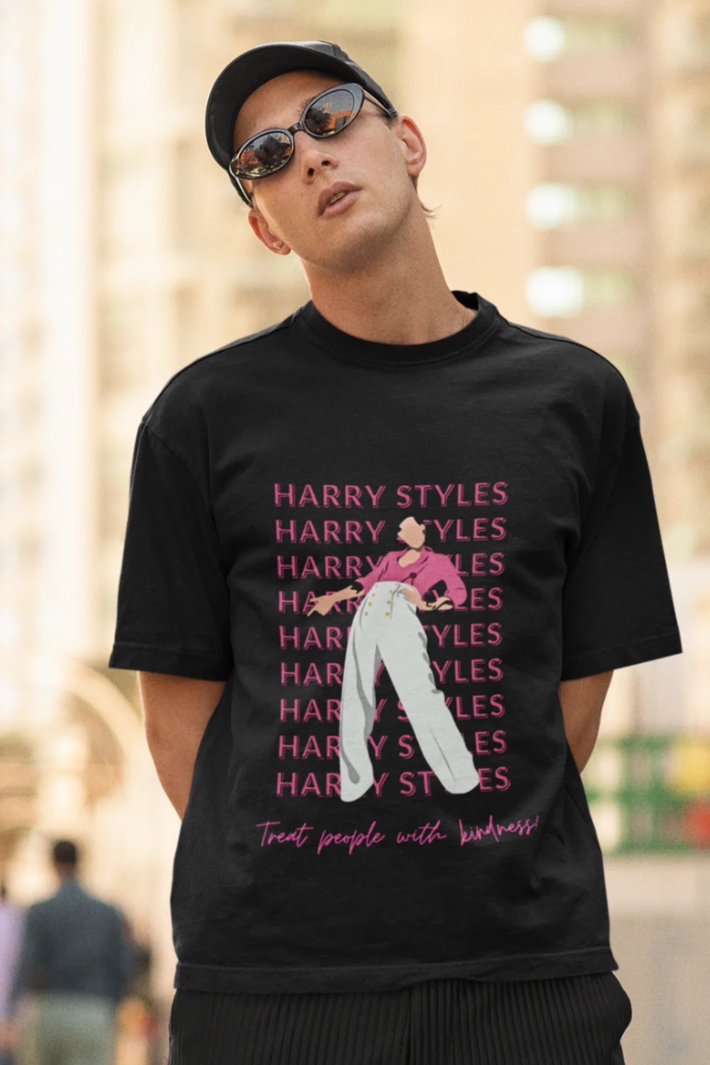 Second image of male model wearing black oversized t-shirt inspired by Harry Styles, featuring the 'Treat People with Kindness' mantra from the Fine Line collection.