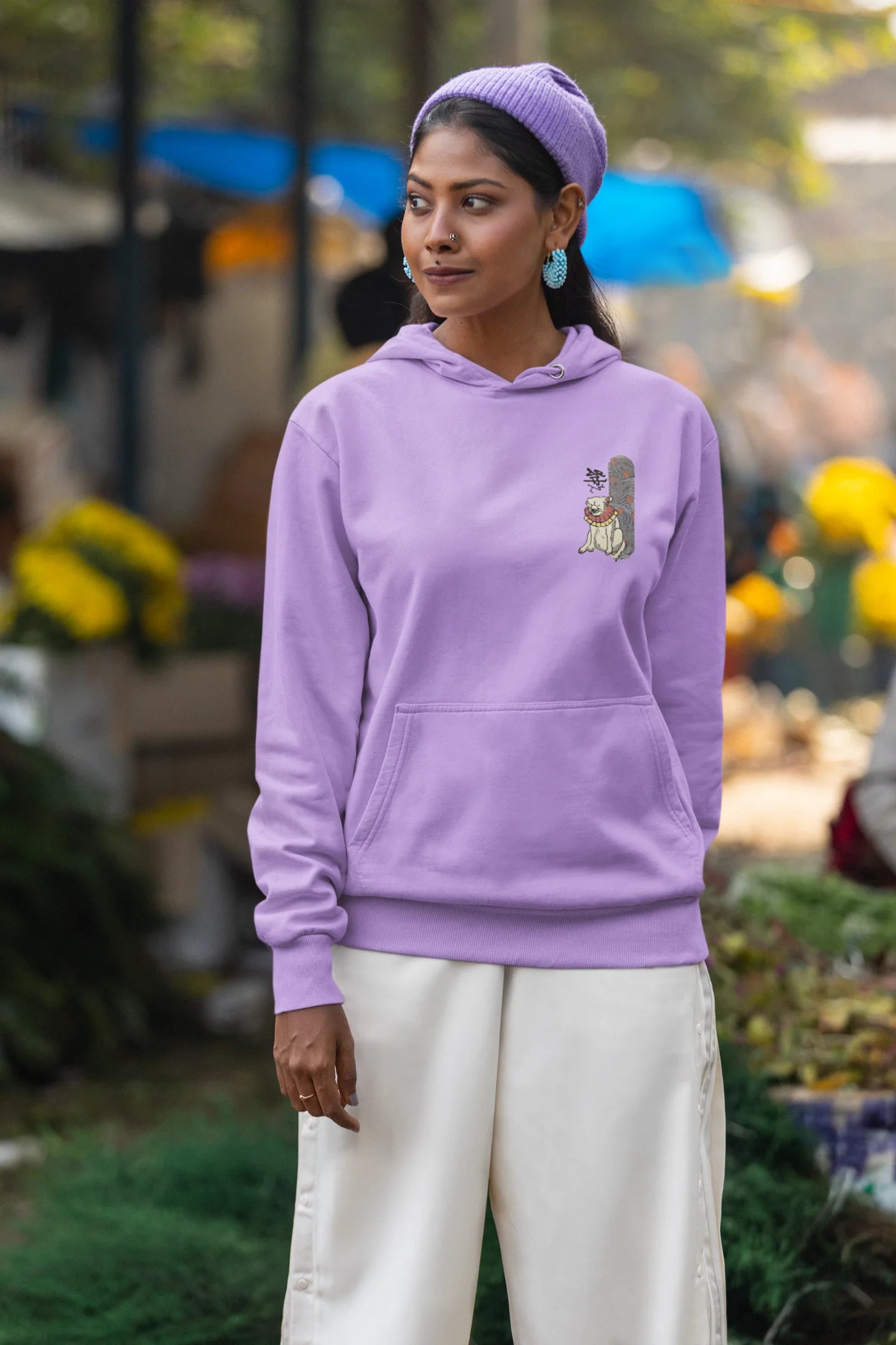 Fourth front view of a female model wearing a lavender hoodie with a design of a mythical Japanese dog.