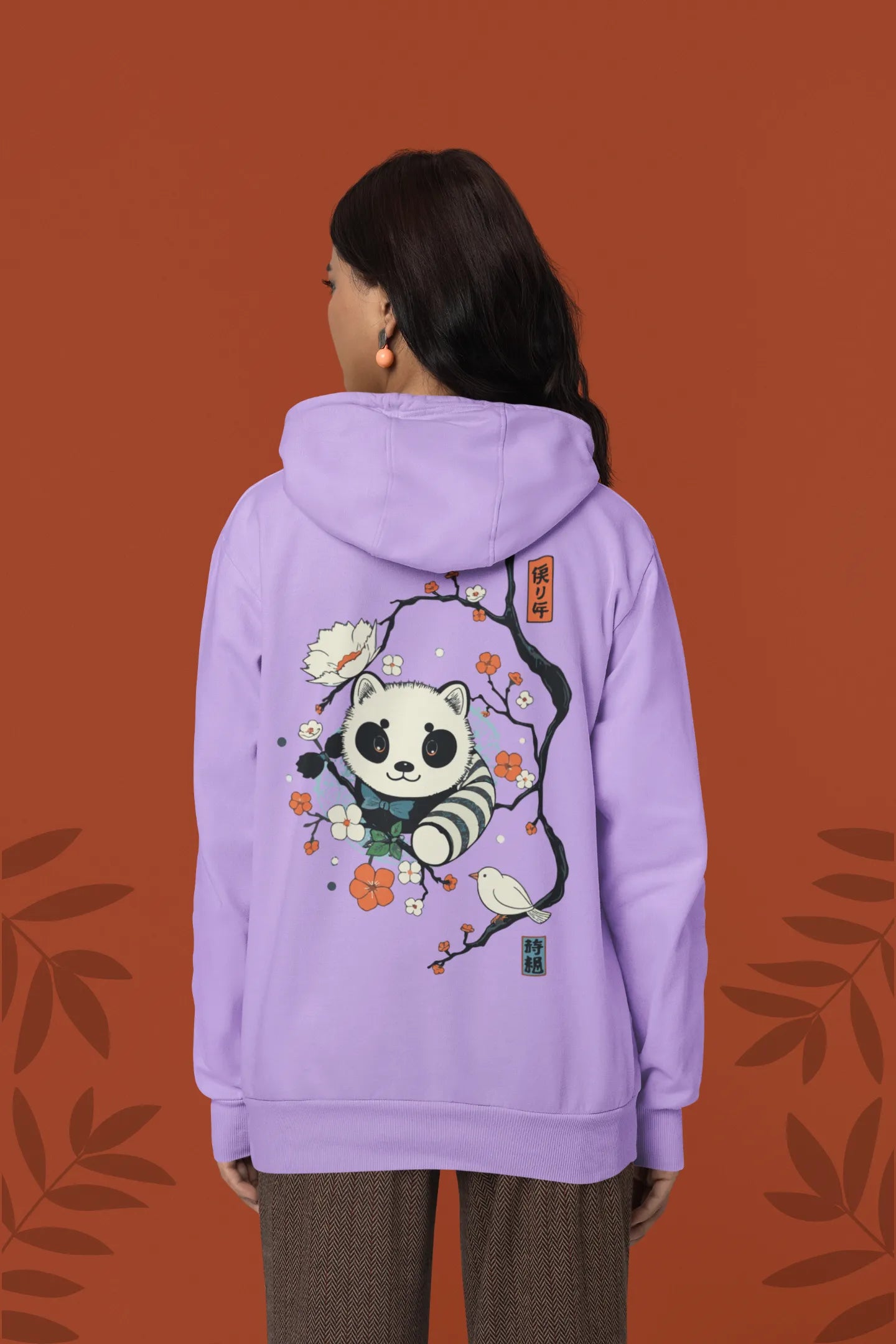 Back view of a female model wearing a lavender hoodie with a panda fox surrounded by bamboo.