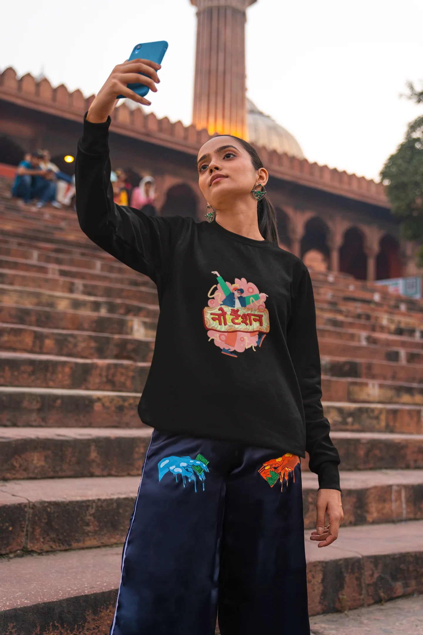 2nd front view of a female model wearing a black oversized t-shirt with the phrase "No Tension" in a relaxed, unique script.