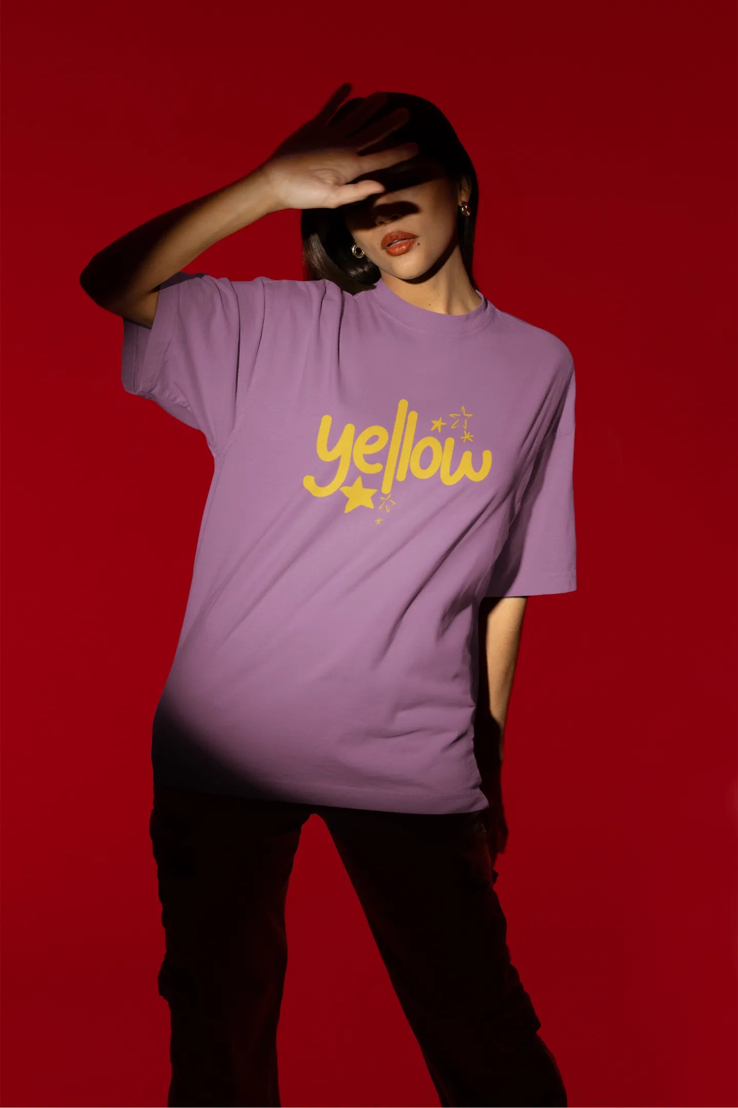 Third front view of a female model wearing a dirty purple oversized t-shirt with the "Yellow" album artwork by Coldplay.