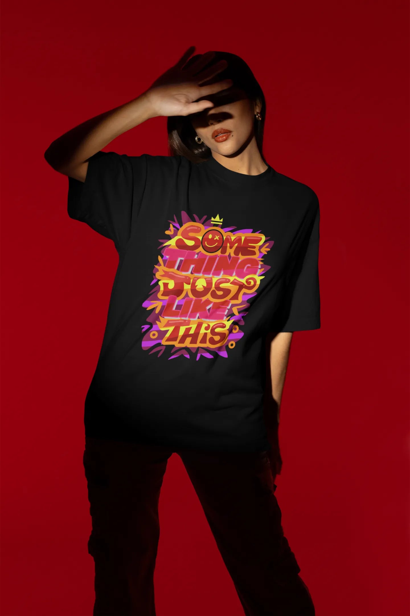 Fourth front view of a female model wearing an black oversized t-shirt featuring the designs inspired from Coldplay's "Something Just Like This" music video.