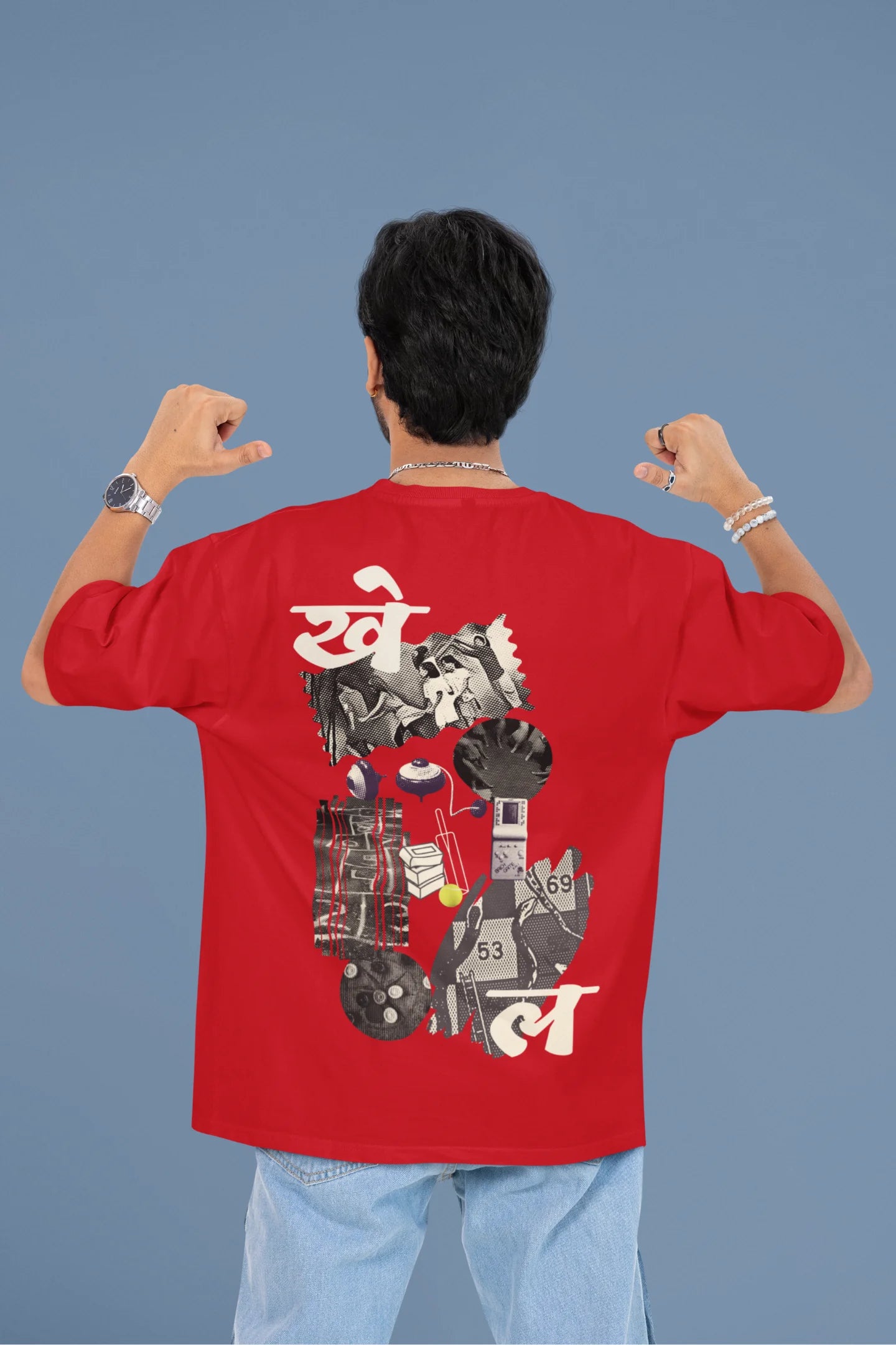 Back view of a male model wearing a red oversized t-shirt featuring a collage of illustrations or symbols representing various childhood games commonly played by kids in India.
