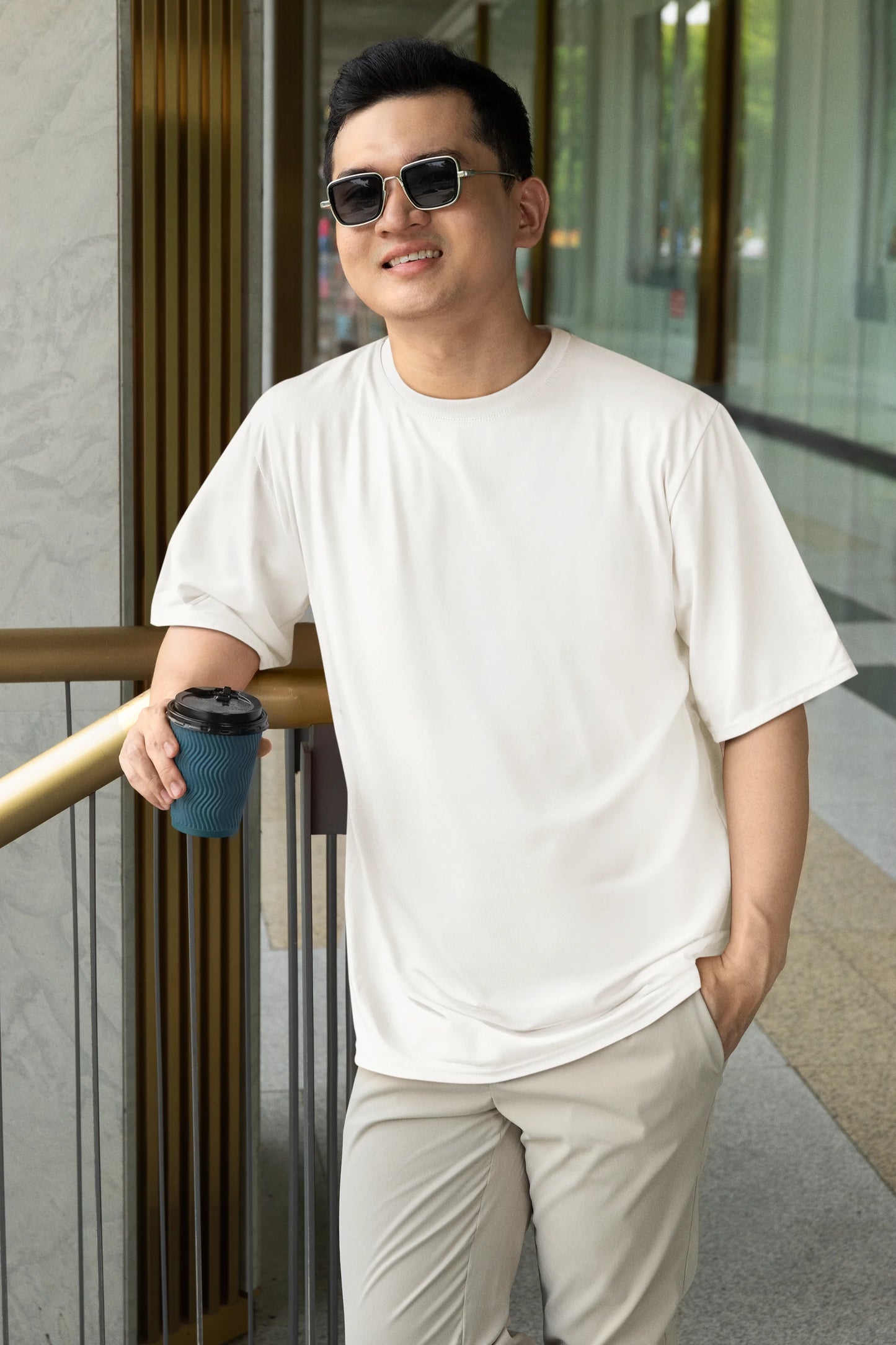 Front view of a male model wearing a off-white oversized tee with a design of a koi fish swimming in a bed of flowers.