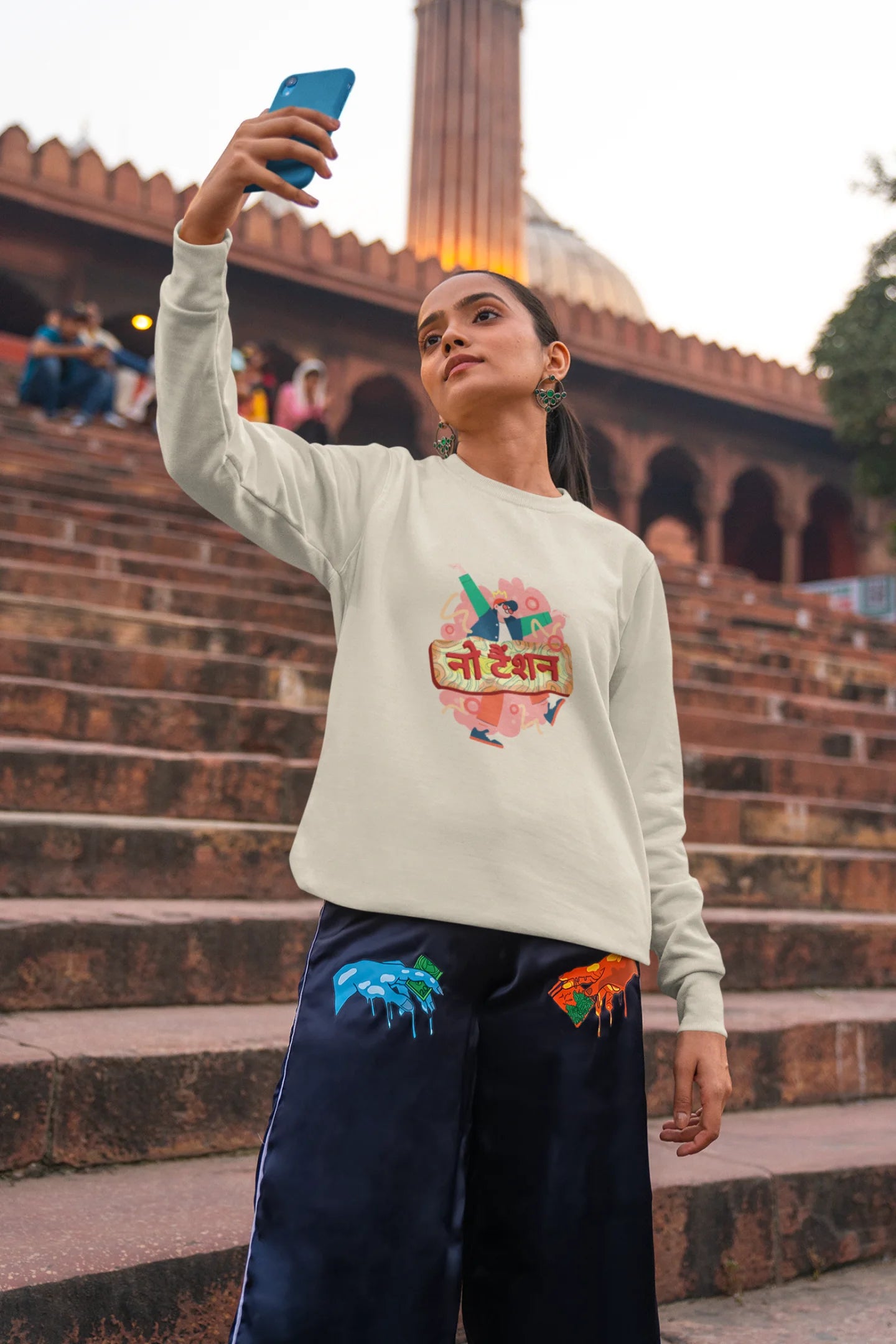 3rd front view of a female model wearing a cream oversized t-shirt with the phrase "No Tension" in a relaxed, unique script.