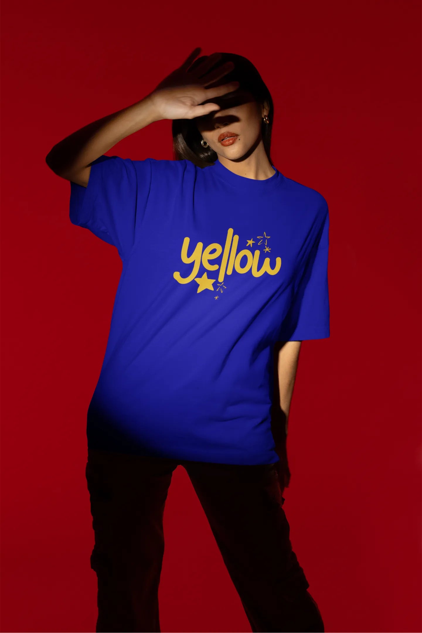 Third front view of a female model wearing a royal blue oversized t-shirt with the "Yellow" album artwork by Coldplay.