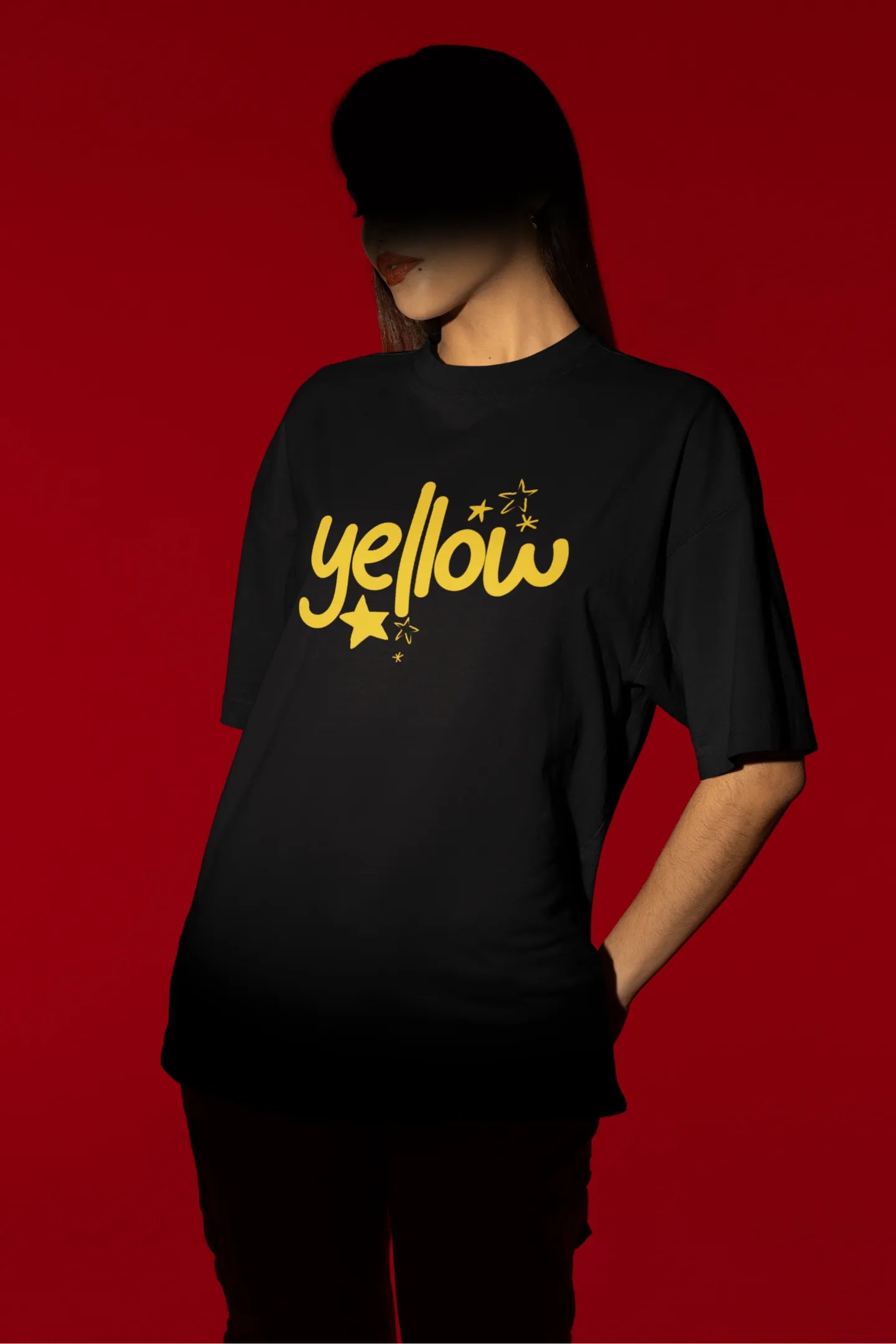 Second front view of a female model wearing a black oversized t-shirt with the "Yellow" album artwork by Coldplay.