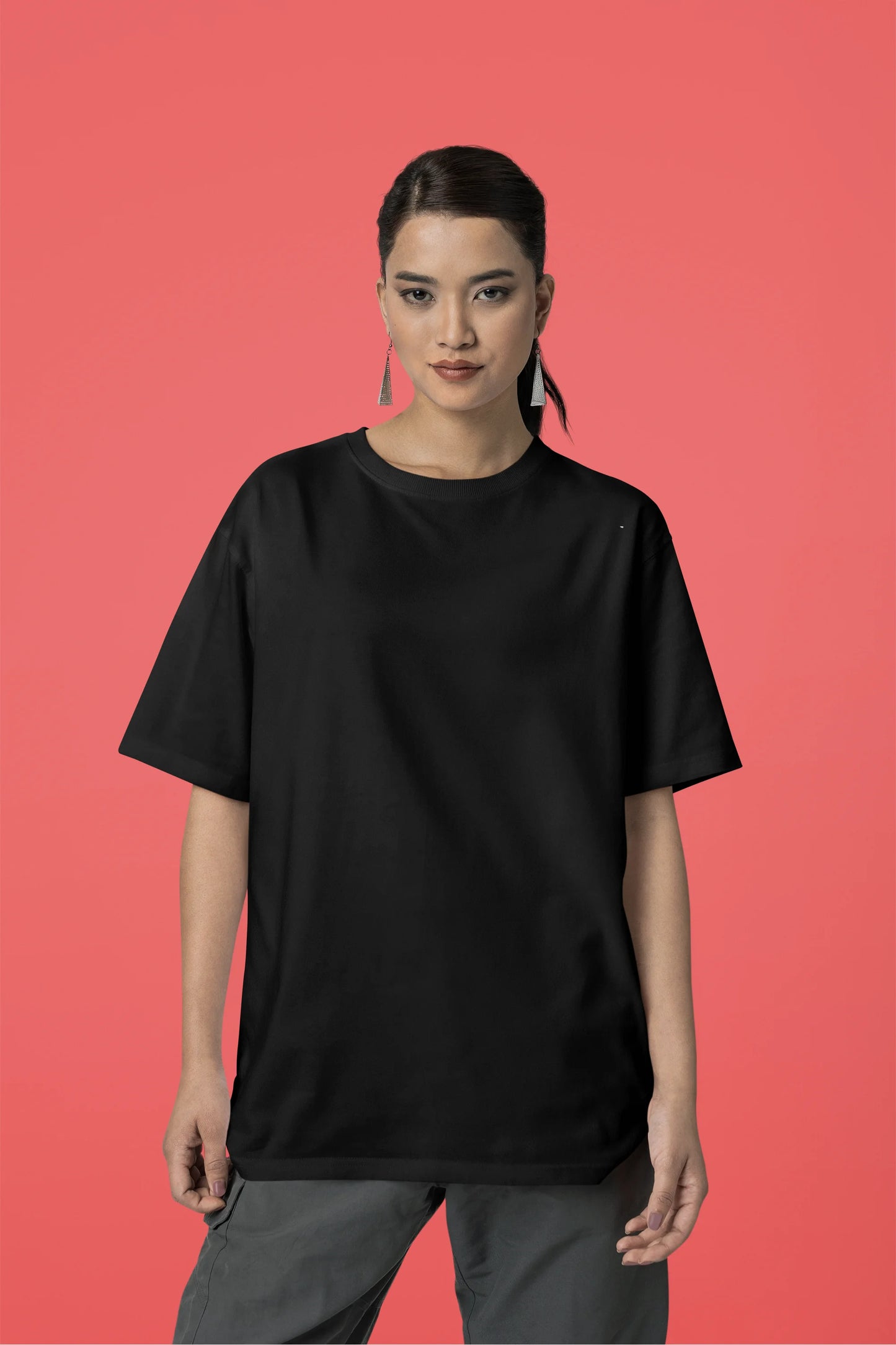 Front view of a female model wearing an oversized black t-shirt featuring a detailed illustration of a gray wolf howling at a full moon in a nighttime setting.