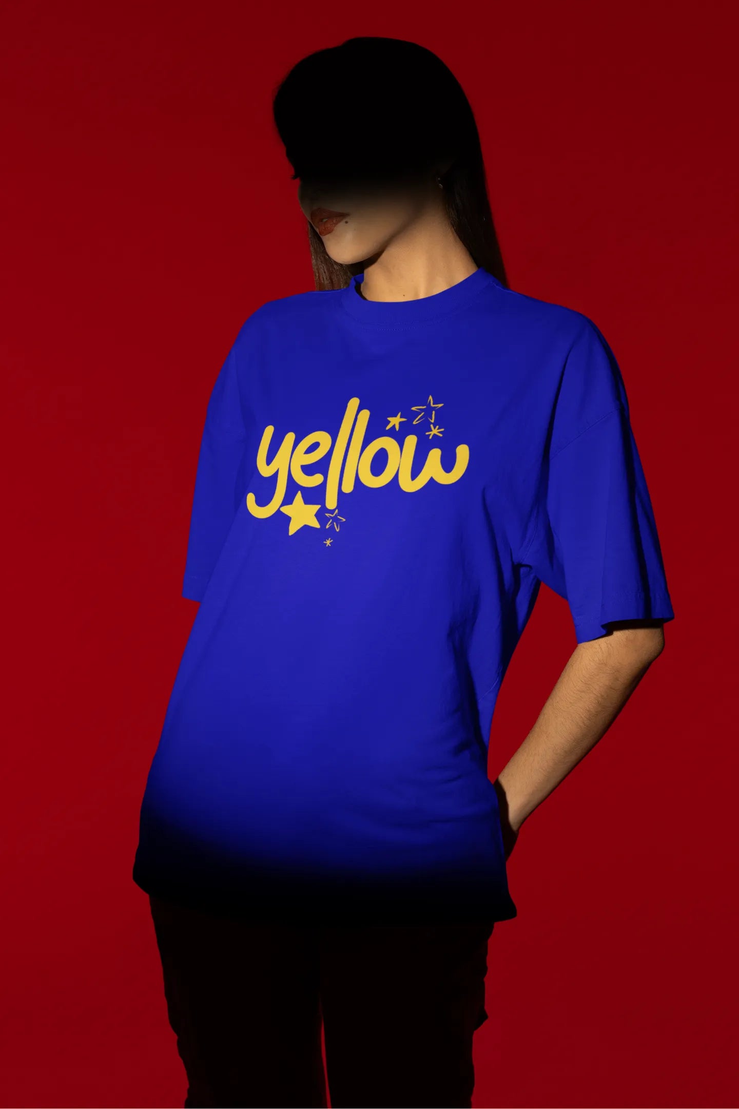 Fourth front view of a female model wearing a royal blue oversized t-shirt with the "Yellow" album artwork by Coldplay.