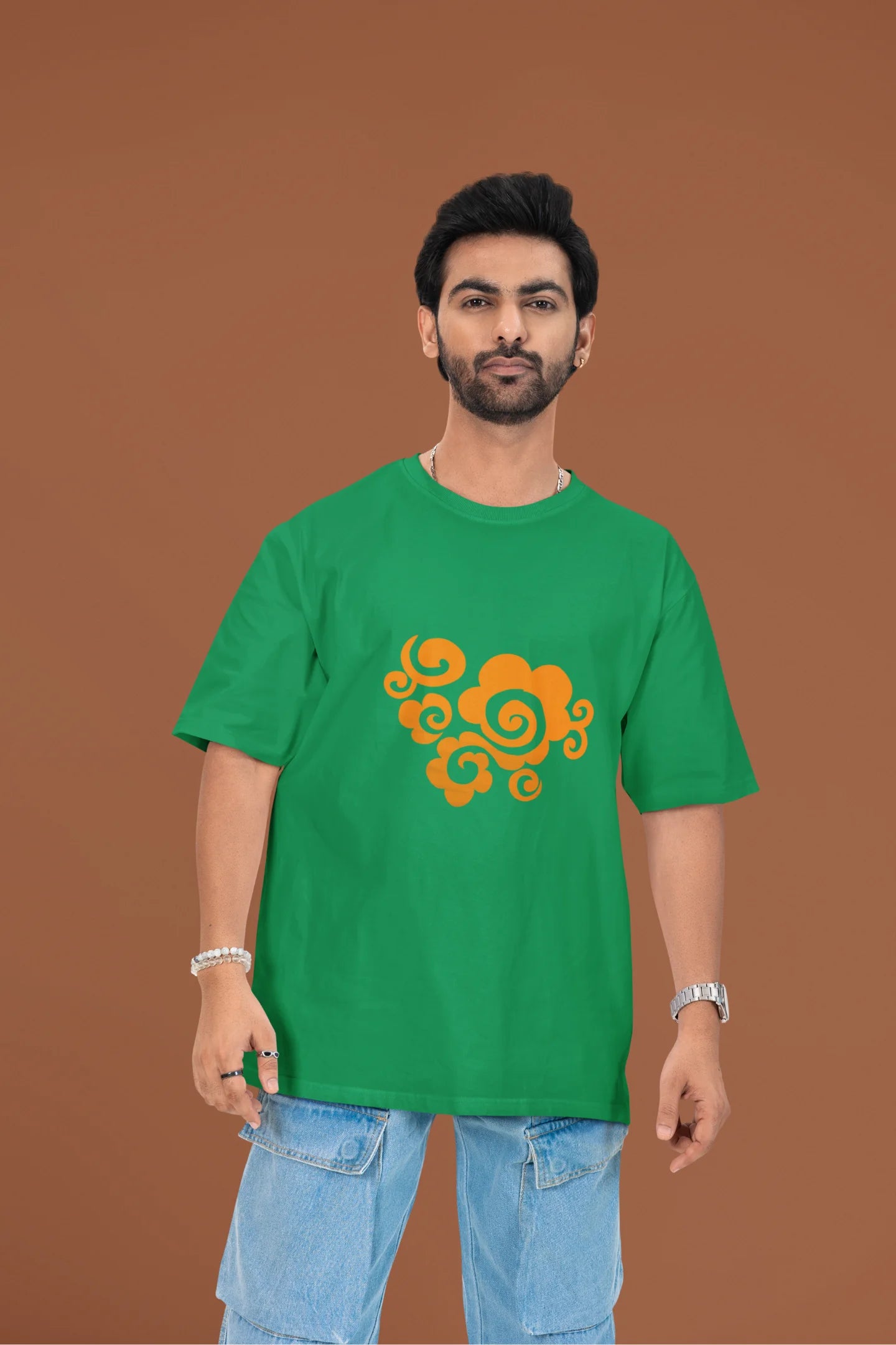 Front view of a male model wearing a forest green oversized t-shirt featuring "Bindass" in a stylish Hindi font.