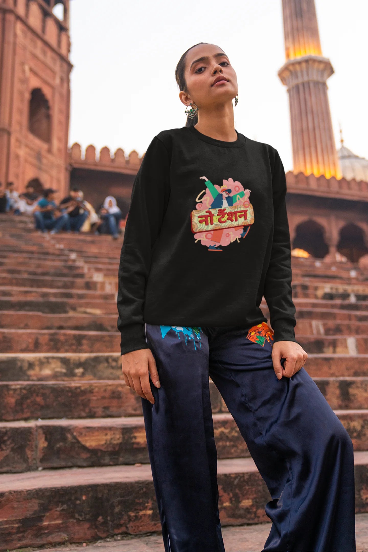 First front view of a female model wearing a black oversized t-shirt with the phrase "No Tension" in a relaxed, unique script.