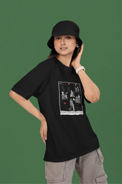 2nd front view of a female model wearing a black oversized t-shirt featuring a design that represents cherished memories, inspired by Ed Sheeran's "Photograph."