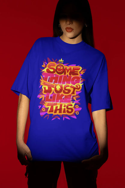 Third front view of a female model wearing an royal blue oversized t-shirt featuring the designs inspired from Coldplay's "Something Just Like This" music video.