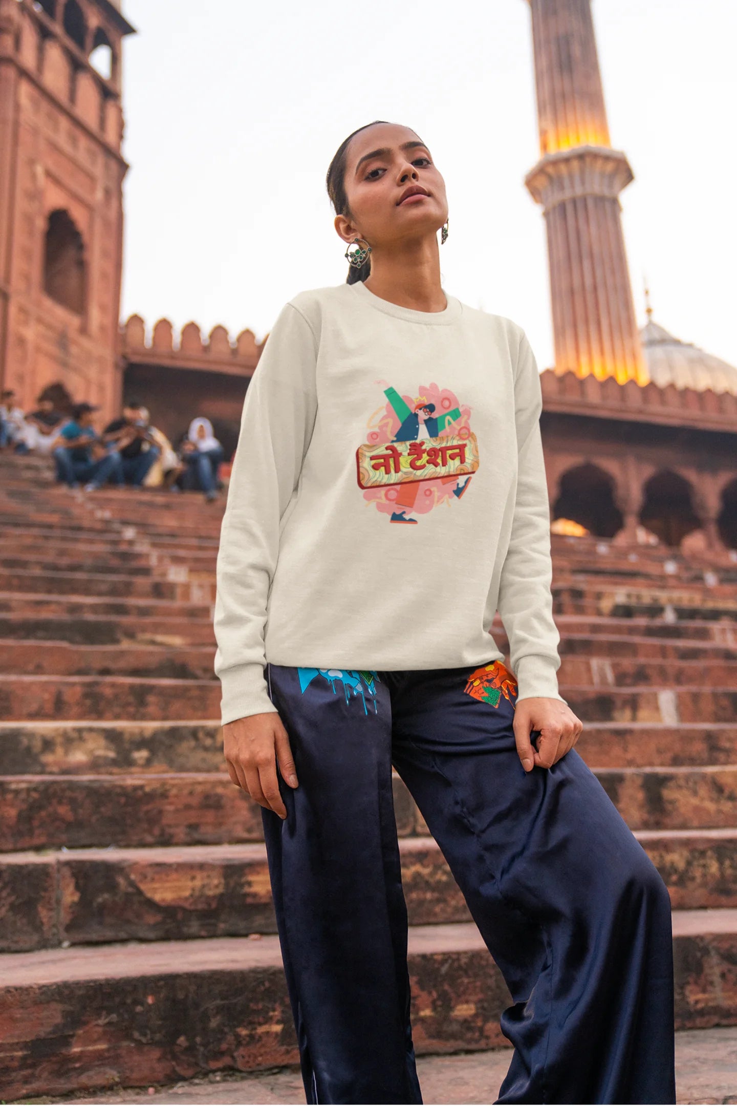 2nd front view of a female model wearing a cream oversized t-shirt with the phrase "No Tension" in a relaxed, unique script.