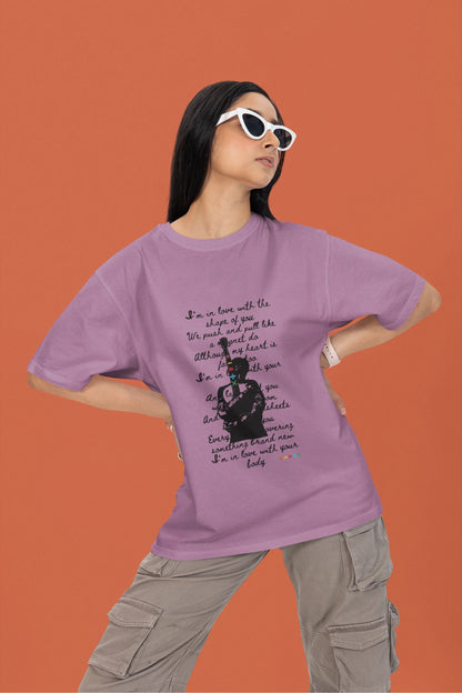 2nd front view of a female model wearing a dirty purple oversized t-shirt featuring a design inspired by Ed Sheeran's concerts, related to the song "Shape of You."
