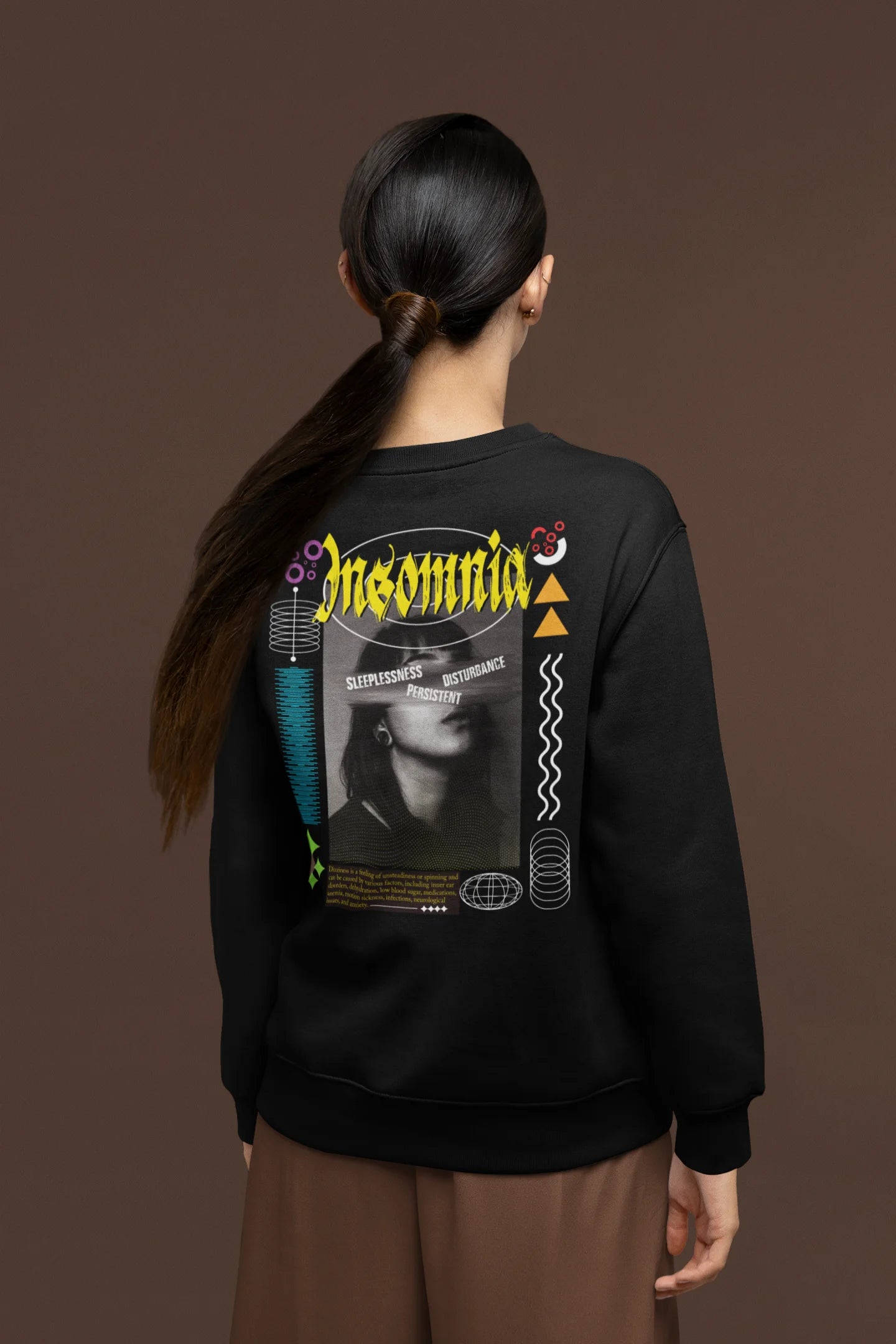 Back view of a female model wearing a brutalist-inspired black sweatshirt with "Insomnia" written in a stylized, concrete-like font.