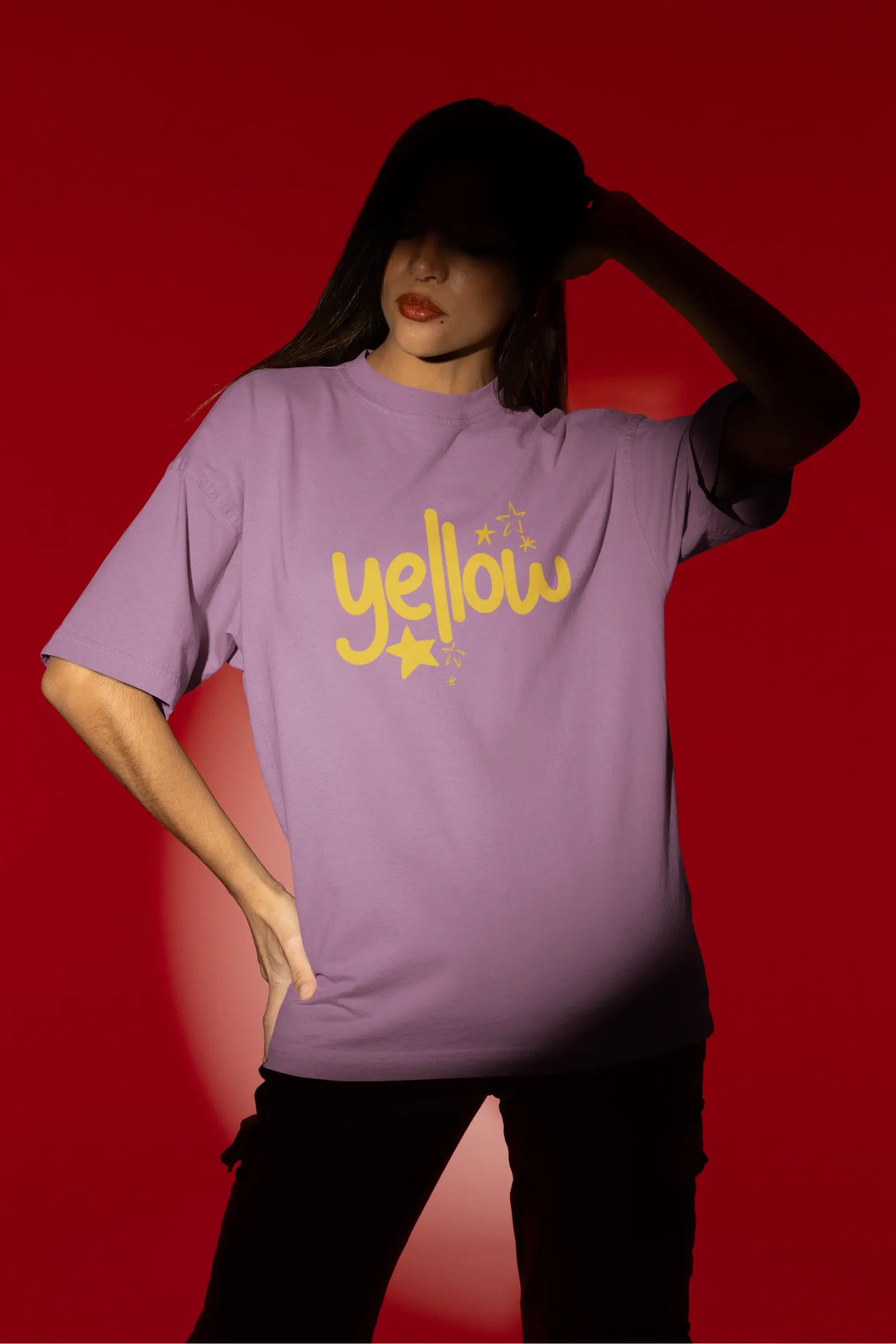 First front view of a female model wearing a dirty purple oversized t-shirt with the "Yellow" album artwork by Coldplay.