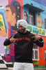 Fourth front view of a male model wearing a black Diljit Dosanjh hoodie with the text 