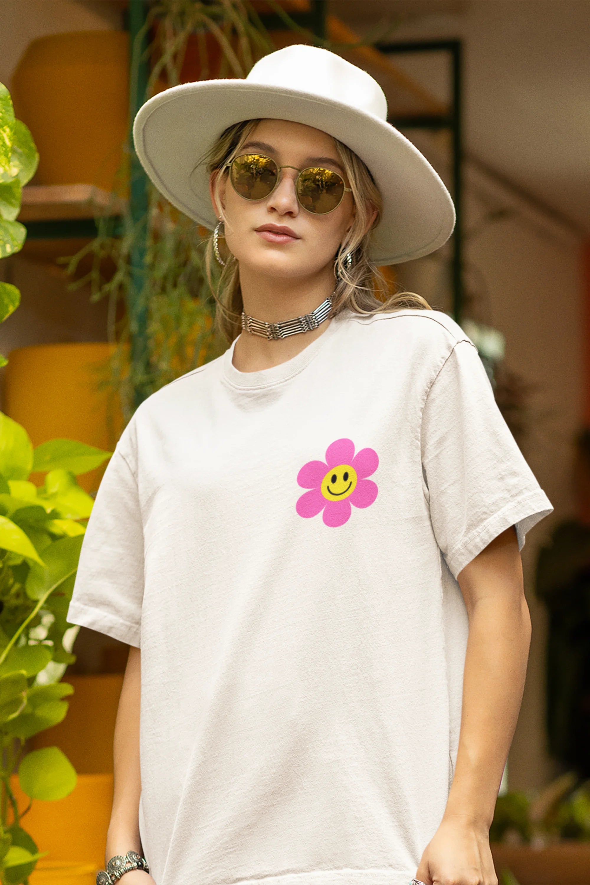 Close up view of a female model wearing an oversized off-white t-shirt with a positive message "Keep Smiling" surrounded by colorful flowers and a smiley face emoji. Ideal for those who love cheerful clothing and spreading positivity.