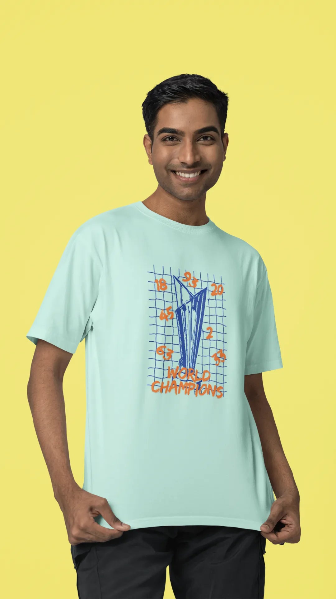 Second front image of male model wearing a mint green oversized t-shirt featuring the World Cup 2024 trophy with the text "World Champions" underneath. Ideal for Indian cricket fans celebrating their team's victory.