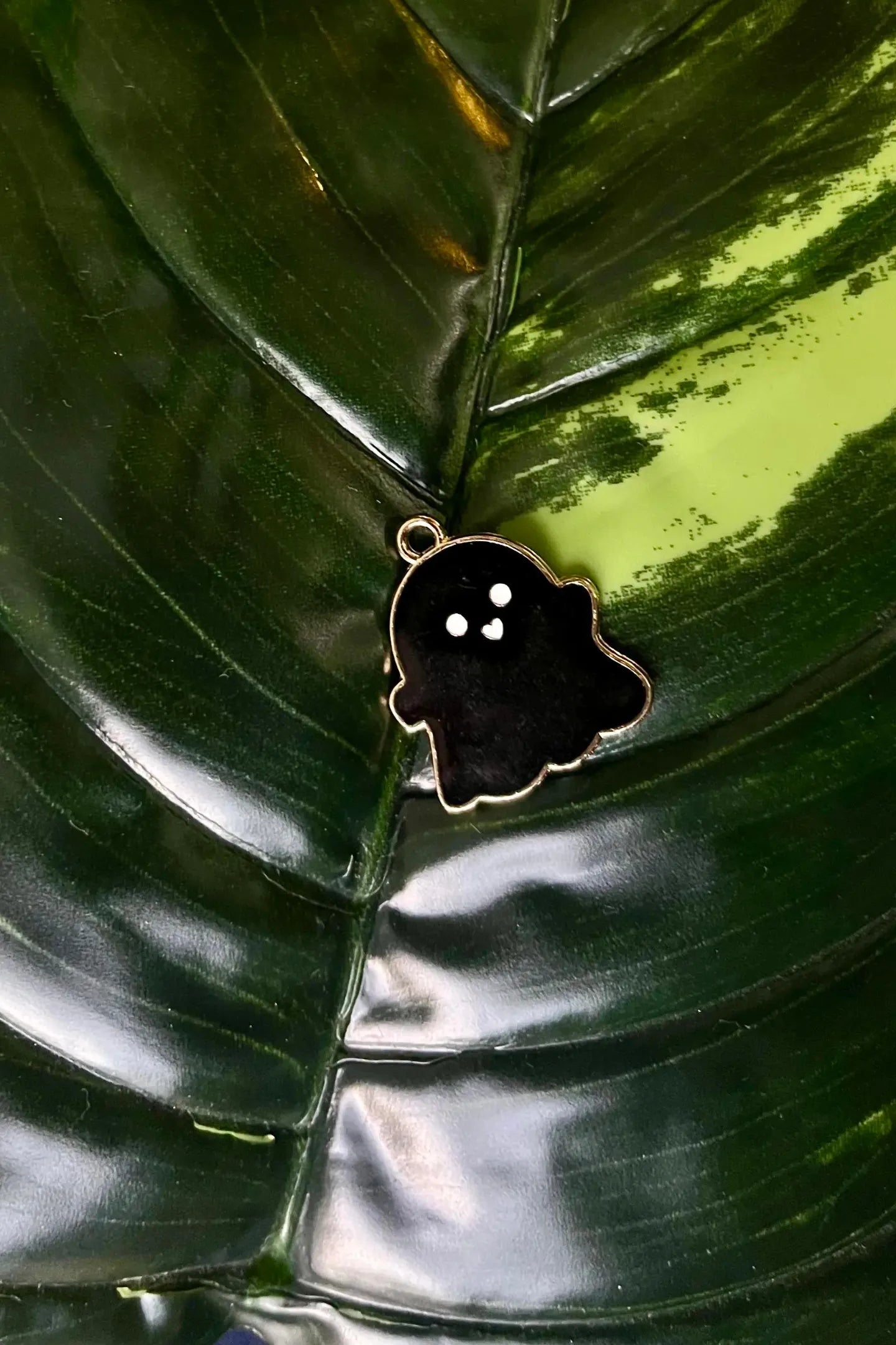 First view of a charm featuring a cute 
 black spooky adorable ghost design.