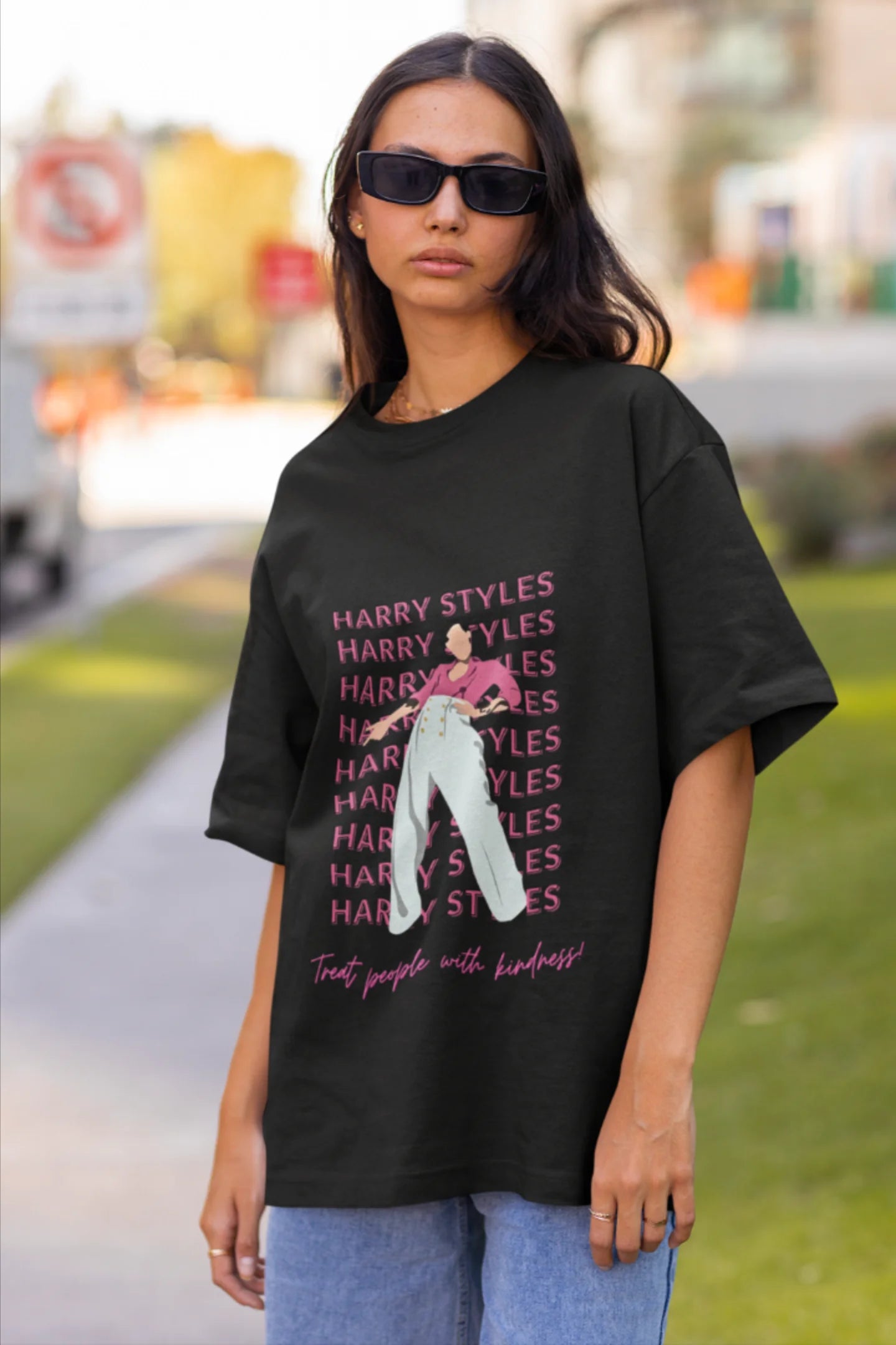 Second image of female model wearing black oversized t-shirt inspired by Harry Styles, featuring the 'Treat People with Kindness' mantra from the Fine Line collection.