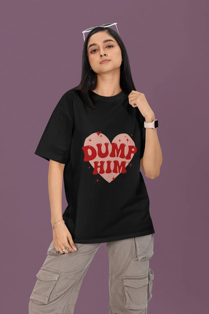 First front view of a female model wearing a black oversized t-shirt with the text "Dump Him" printed on it.