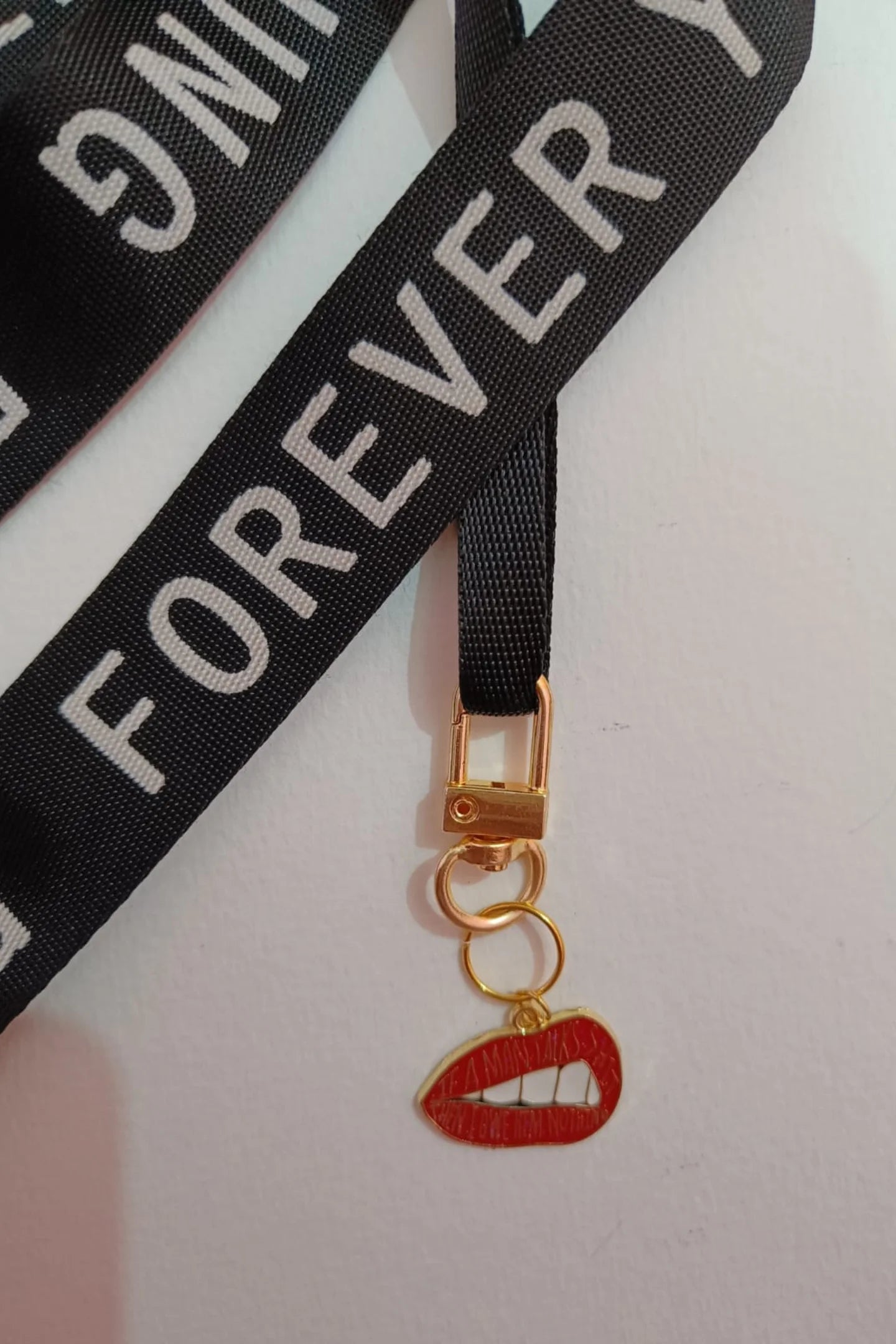 Second image of an keychain featuring the Taylor Swift phrase "You Owe Him Nothing" on a lip design. Perfect for all Swifties.