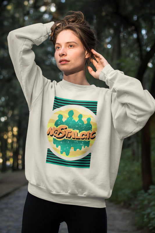 First view of a female model wearing an oversized cream sweatshirt with a shadow silhouette of the Coldplay band members and the word "Nostalgic" printed on it.