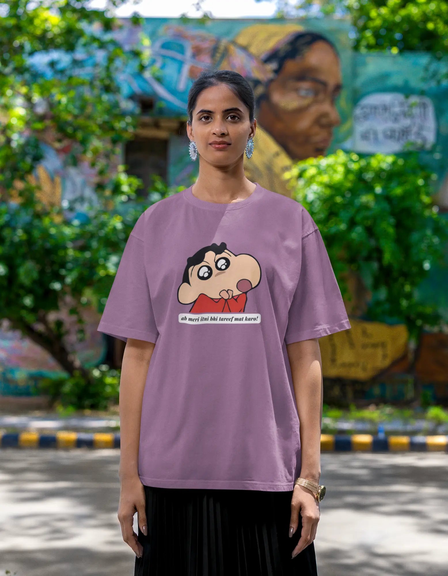 Second front view of female model wearing an oversized dirty purple tee featuring Shinchan with the text "Don't Praise Me So Much" in Hindi. A perfect blend of humor and nostalgia for Shinchan fans.