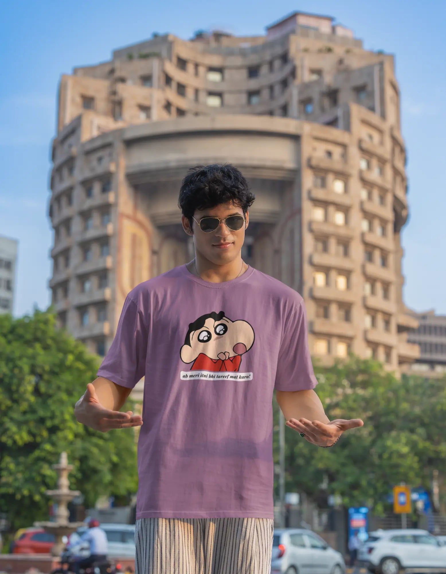 Third front view of male model wearing an oversized dirty purple tee featuring Shinchan with the text "Don't Praise Me So Much" in Hindi. A perfect blend of humor and nostalgia for Shinchan fans.