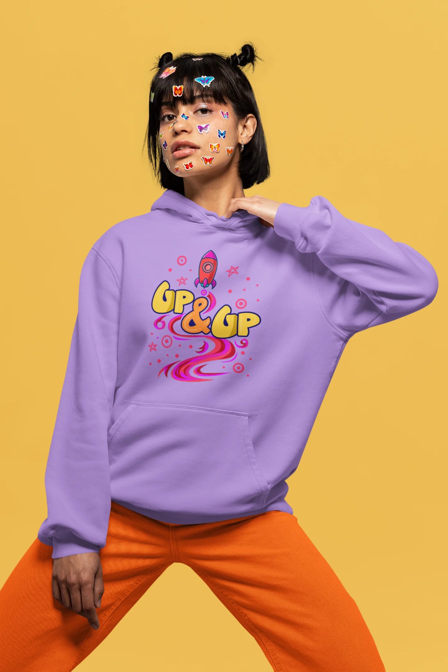 Fourth front view of a female model wearing an lavender hoodie with a rocket ship design and the text "Up & Up".
