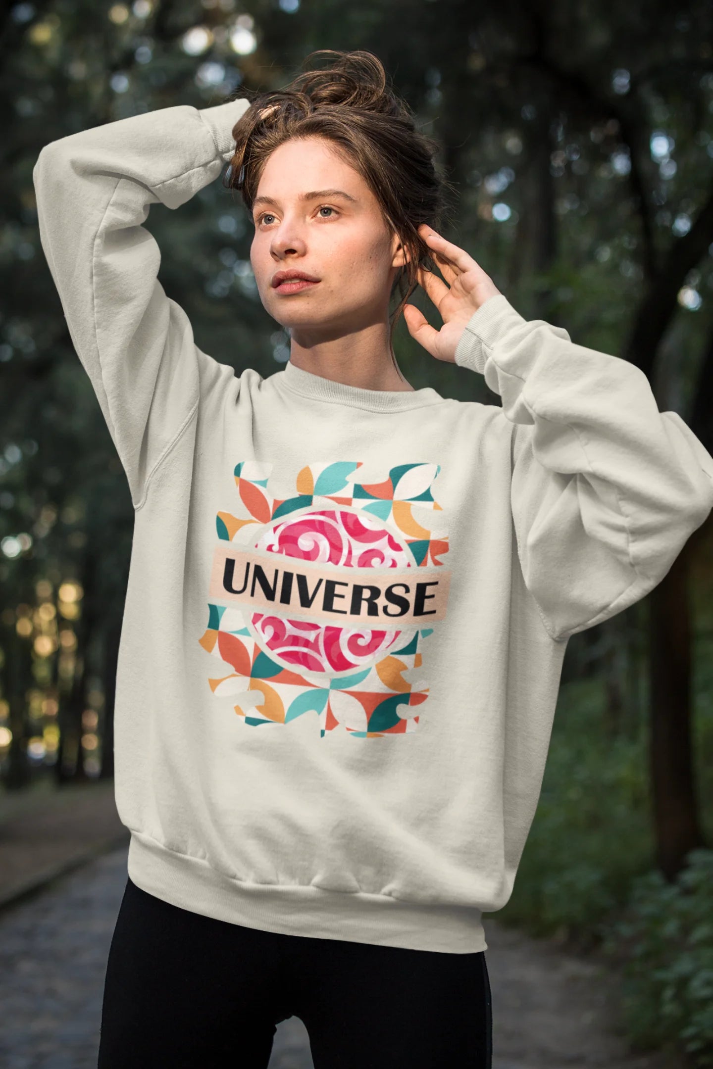First front view of a female model wearing an cream sweatshirt with a cosmic Universe design inspired by Coldplay.