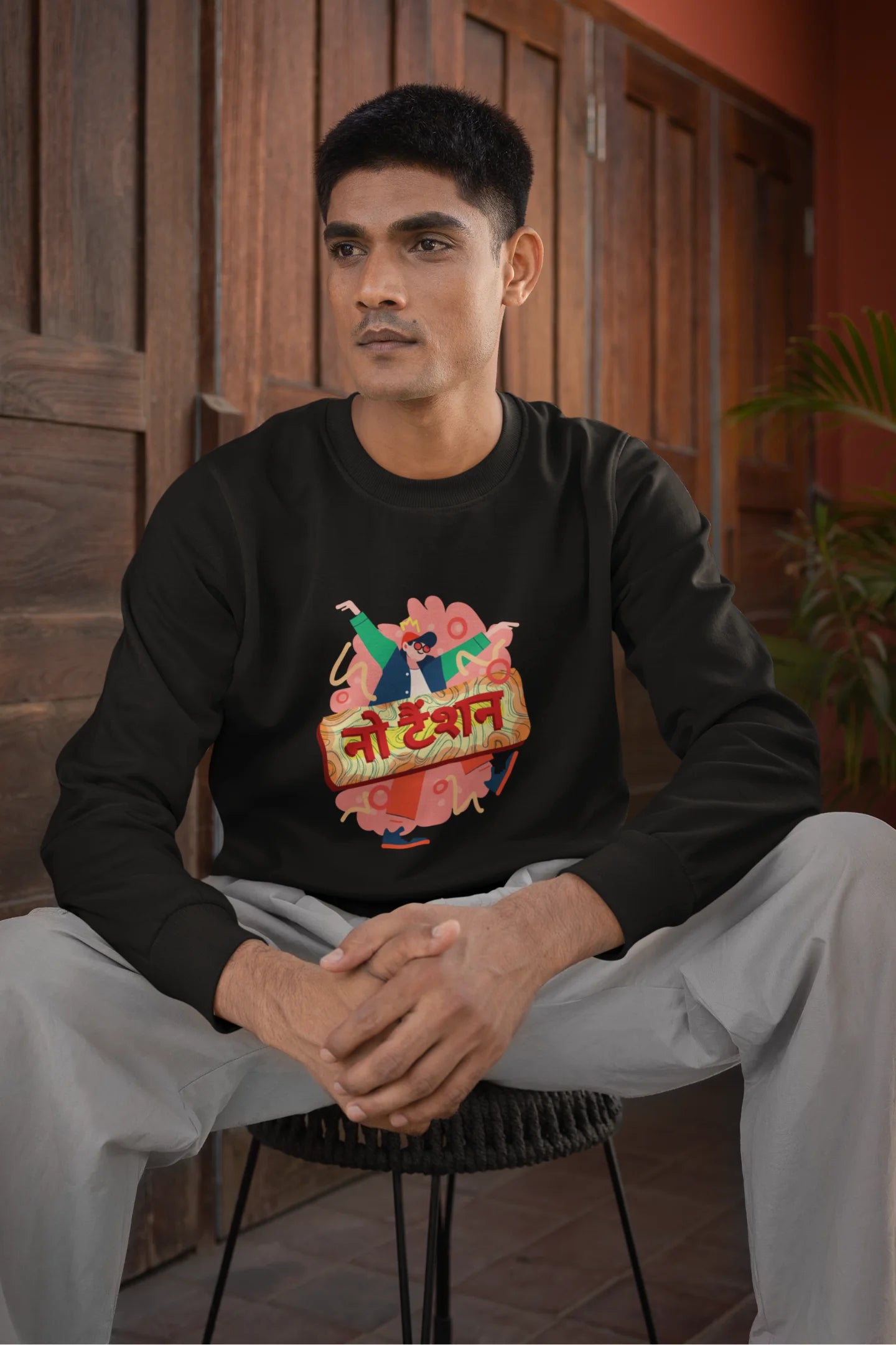 First front view of a male model wearing a black oversized t-shirt with the phrase "No Tension" in a relaxed, unique script.