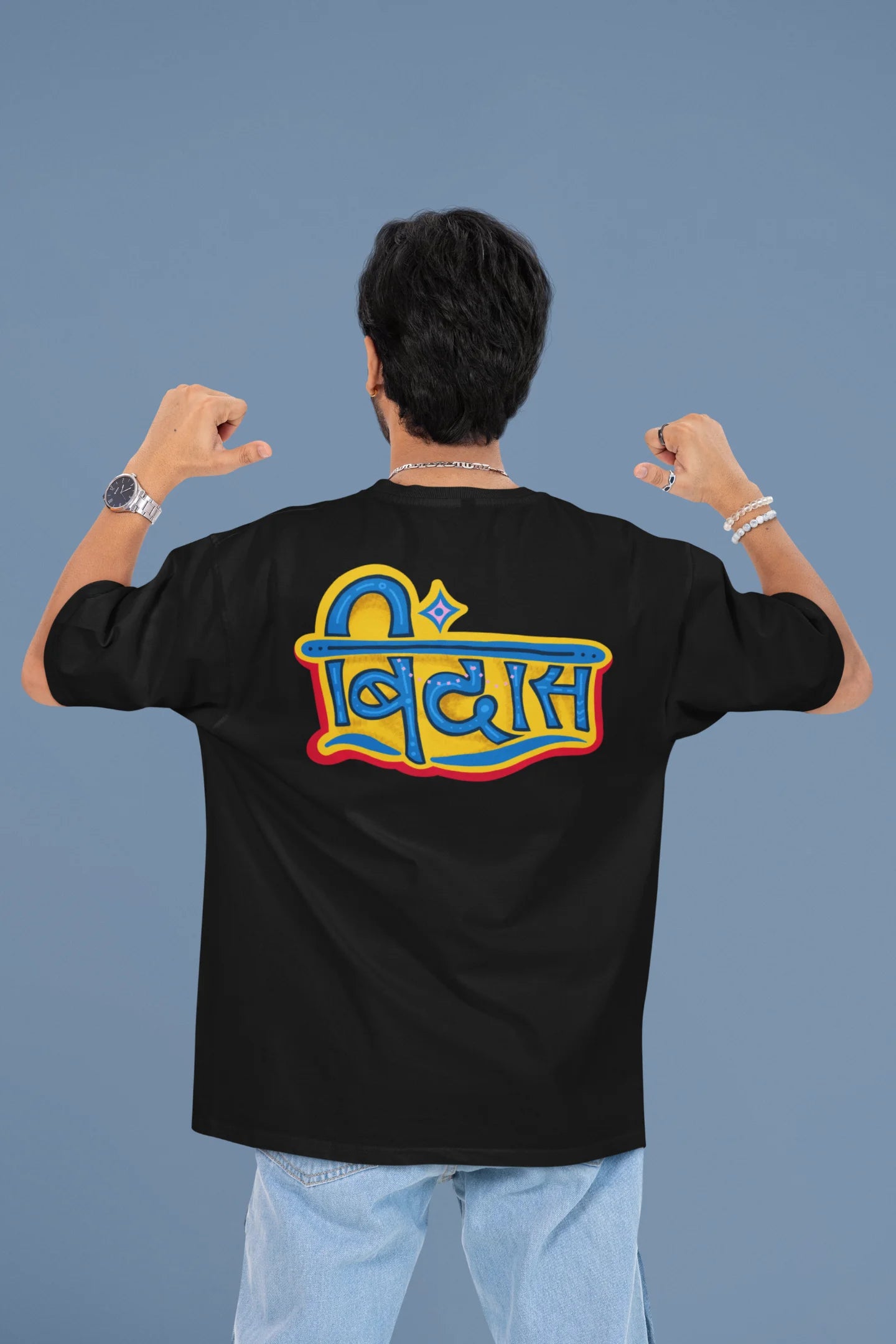 Back view of a male model wearing a black oversized t-shirt featuring "Bindass" in a stylish Hindi font.