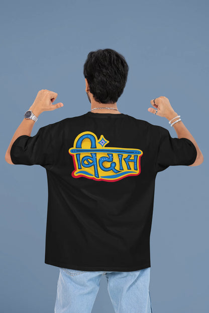 Back view of a male model wearing a black oversized t-shirt featuring "Bindass" in a stylish Hindi font.