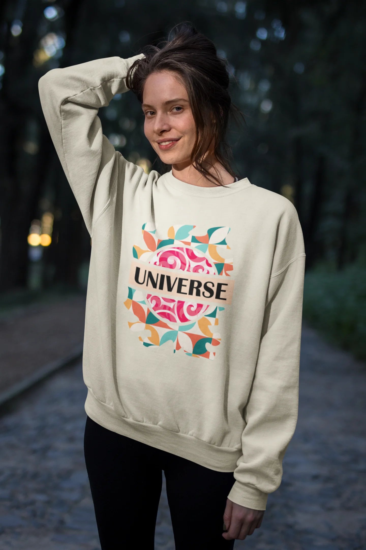 Third front view of a female model wearing an cream sweatshirt with a cosmic Universe design inspired by Coldplay.