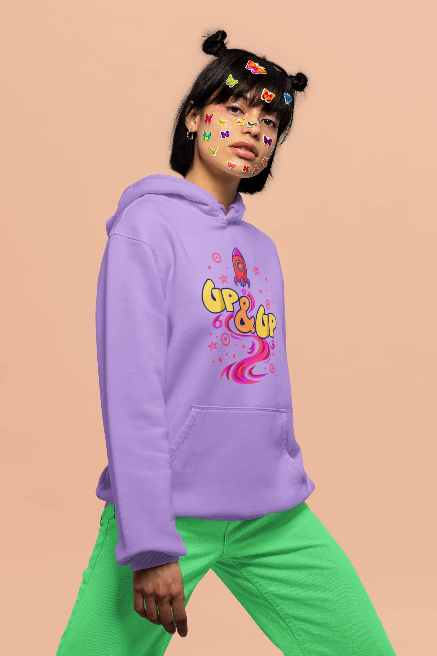 Fifth front view of a female model wearing an lavender hoodie with a rocket ship design and the text "Up & Up".