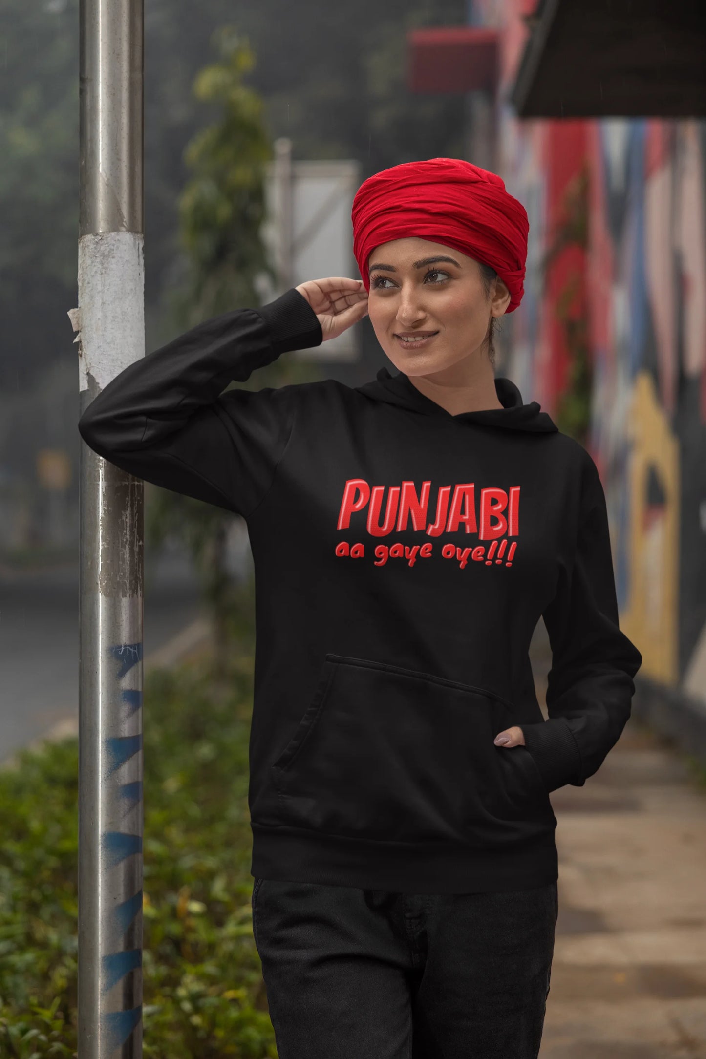 First front view of a female model wearing an black hoodie with the text "Punjabi Aa Gaye".
