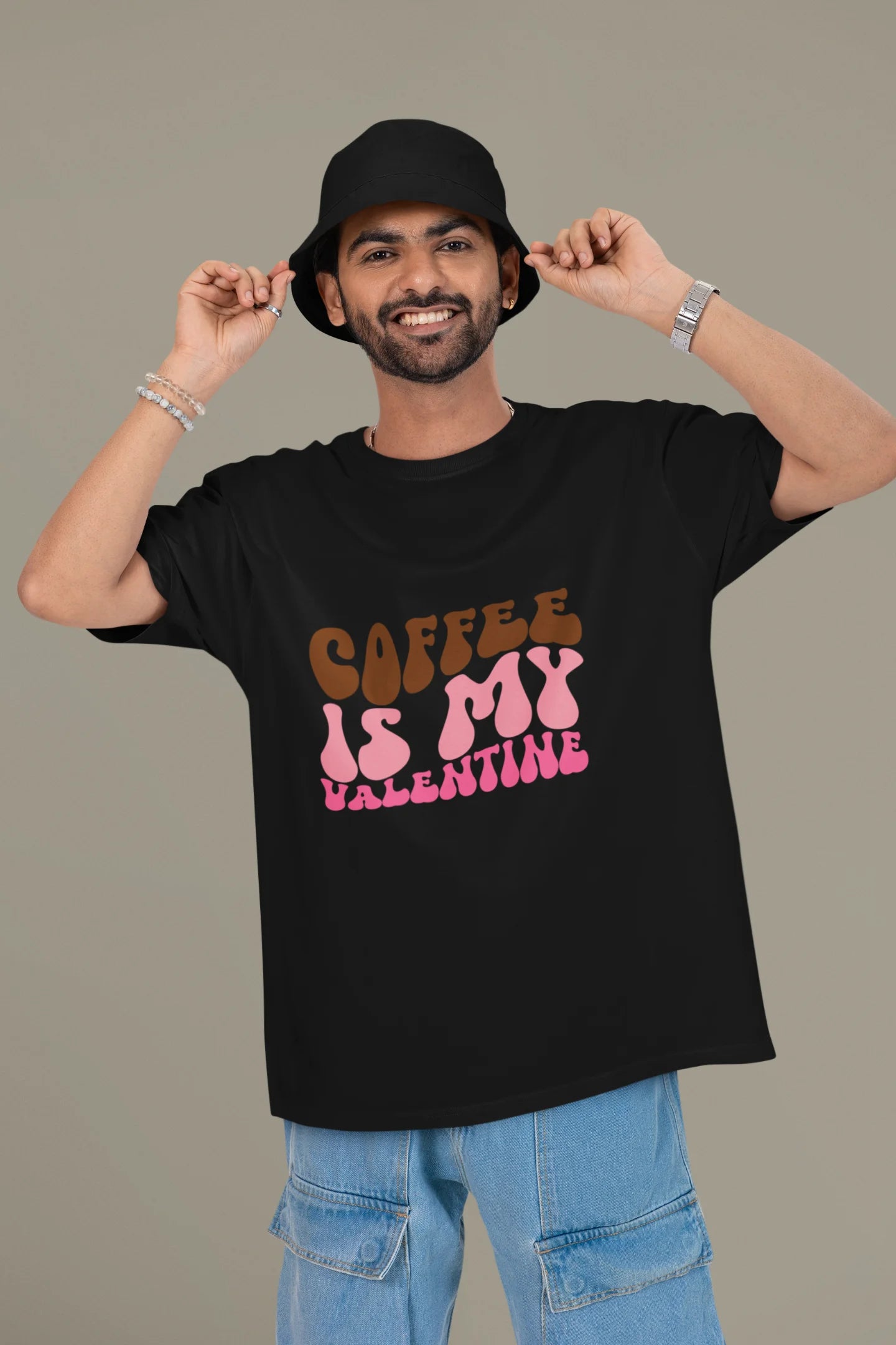 2nd front view of a male model wearing a black oversized t-shirt with the text "Coffee is My Valentine" printed on it.