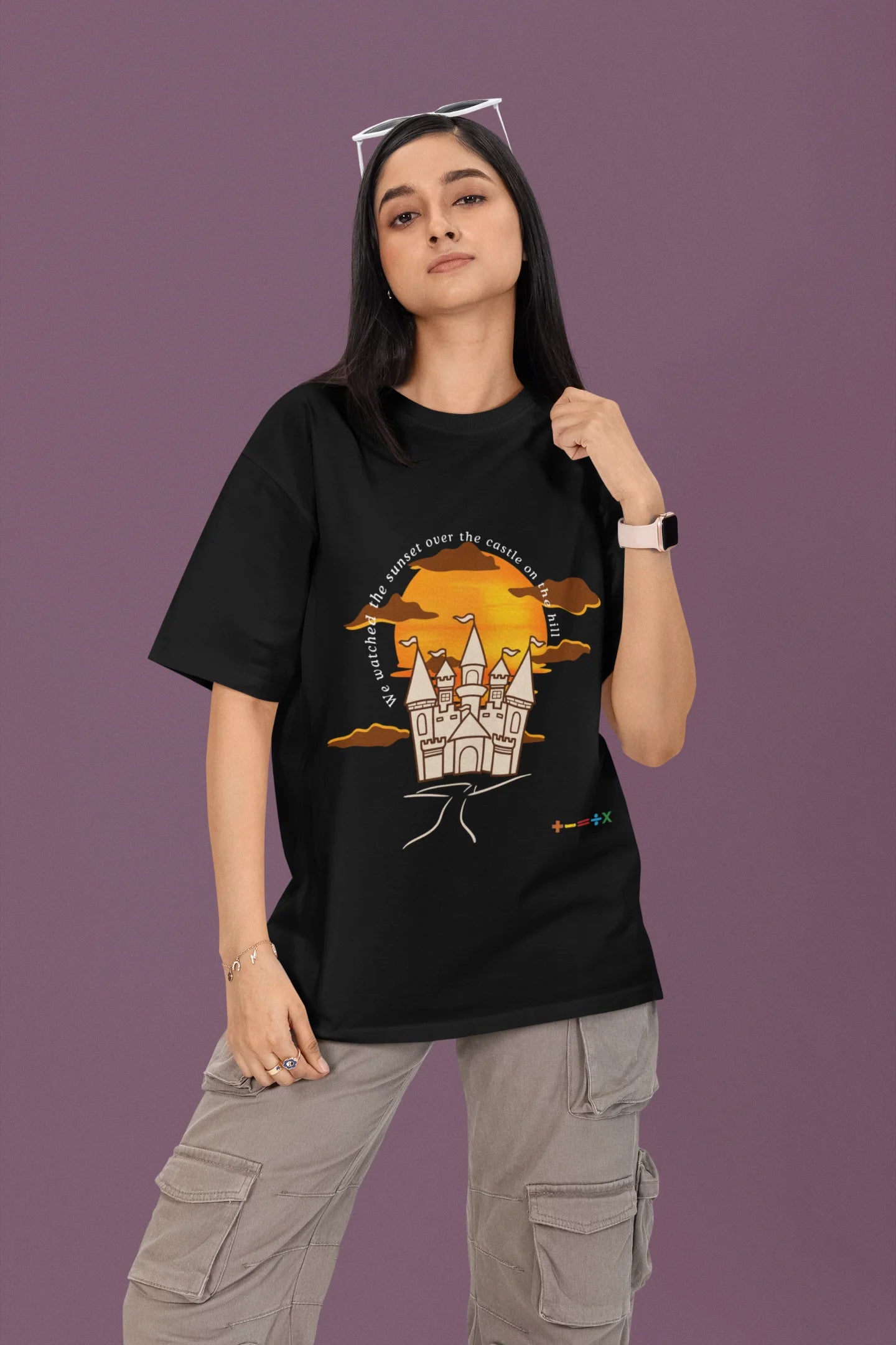 First front view of a female model wearing a black oversized t-shirt featuring a nostalgic sunset and castle design, related to Ed Sheeran's "Castle on the Hill."